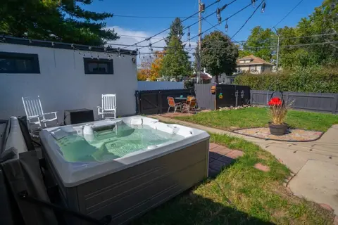Shared hot tub in the fenced backyard, open to guests of all four apartments