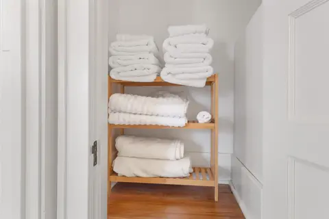 Stacked bath towels, hand towels, and washcloths on an open shelf