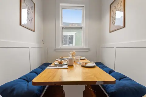 Breakfast nook seating four on blue bench cushions under the window