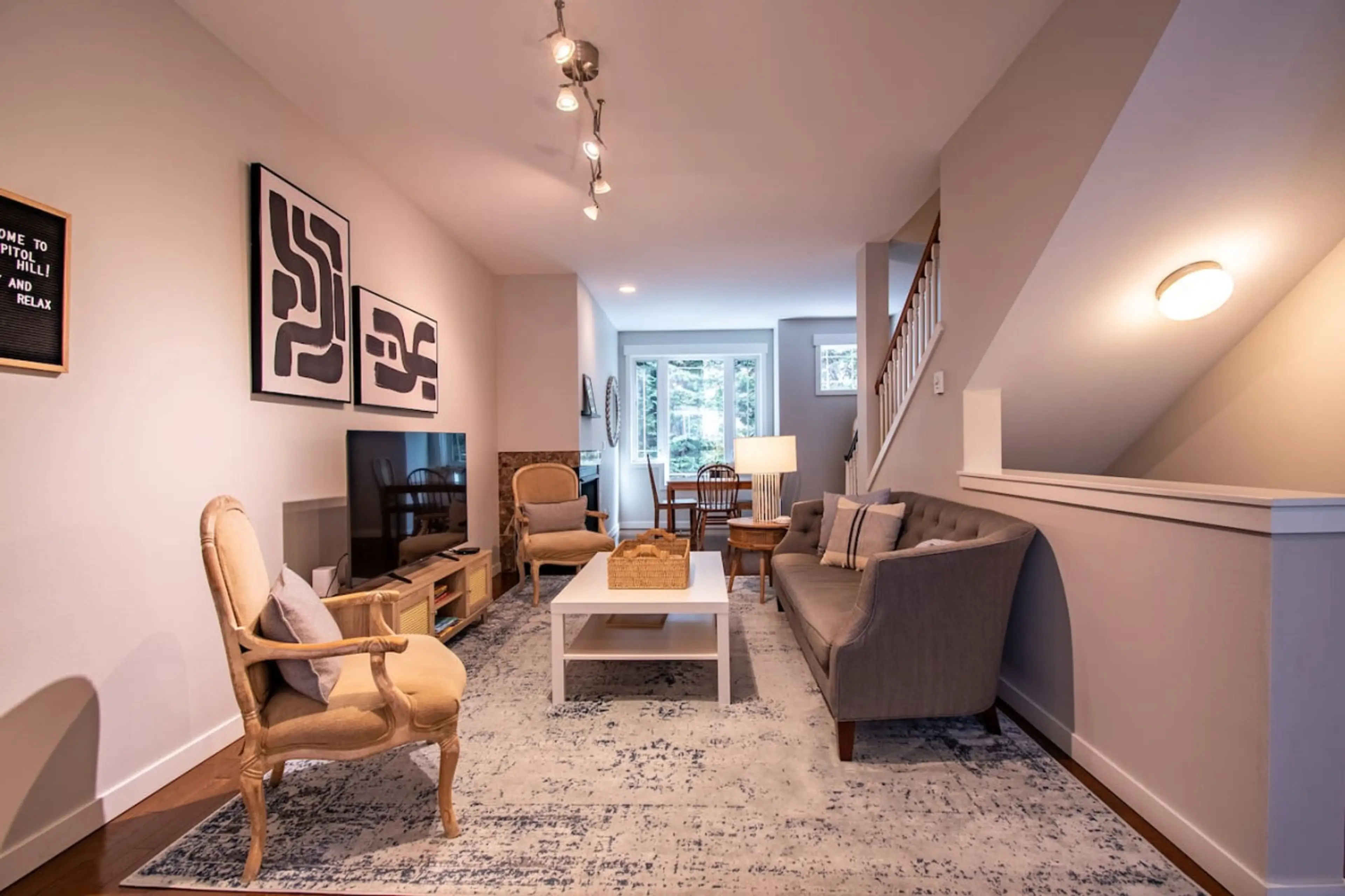 Living area with a comfortable sofa, a center table, two chairs, and a TV, making it the ideal spot for relaxation and fun.