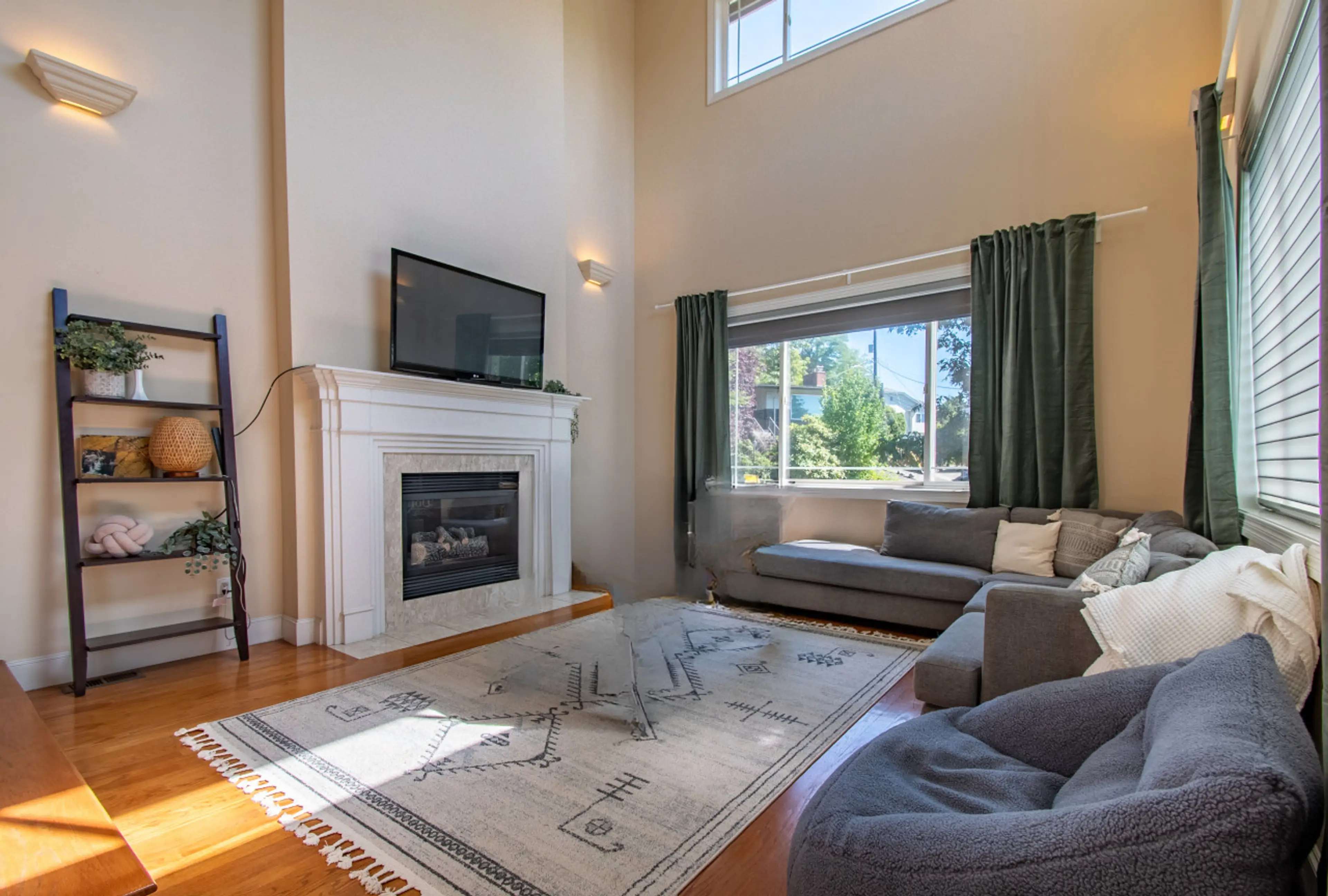 Roomy living room equipped with a fireplace and a TV for comfort and entertainment.