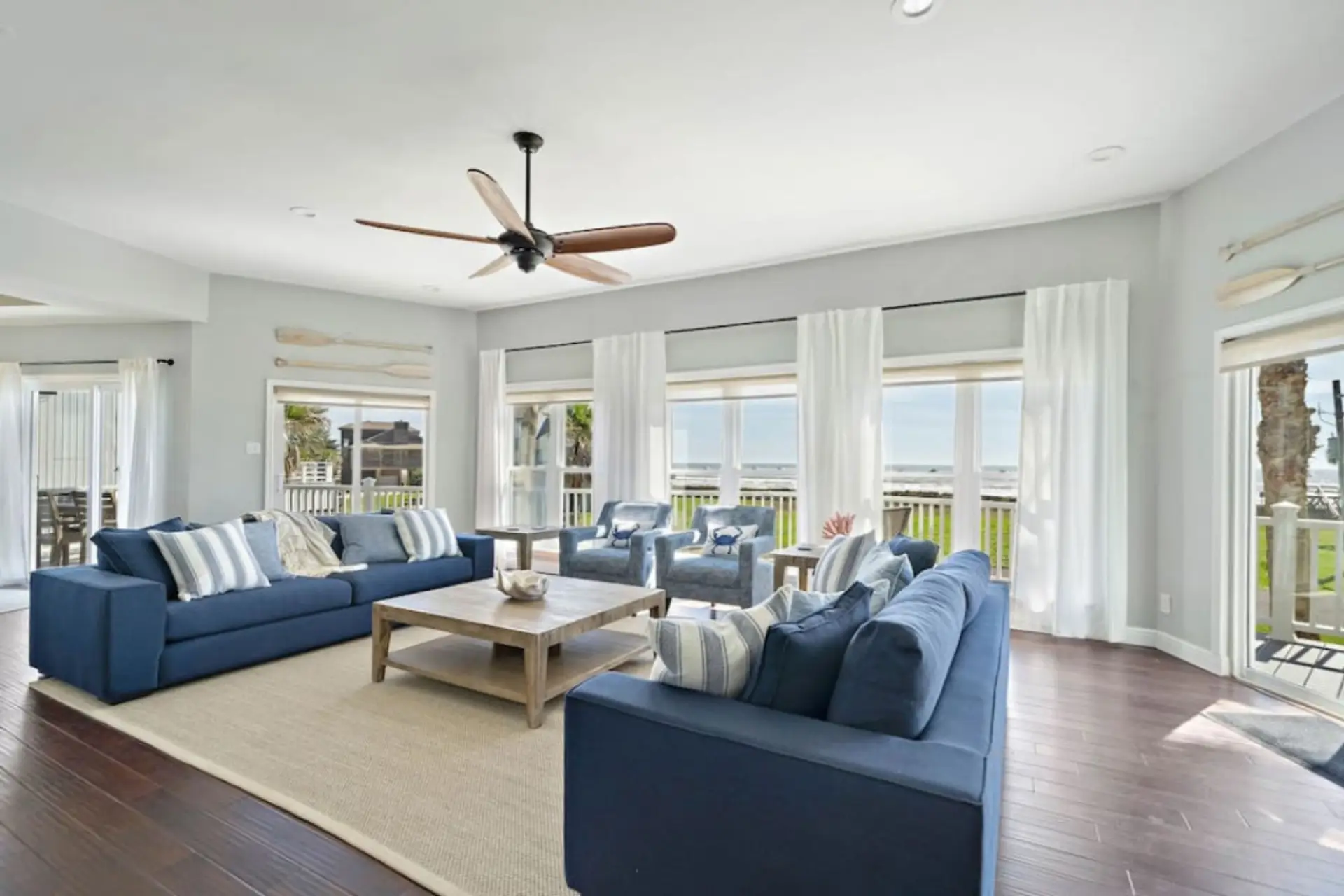 The living room has a 65-inch flatscreen television and ocean views