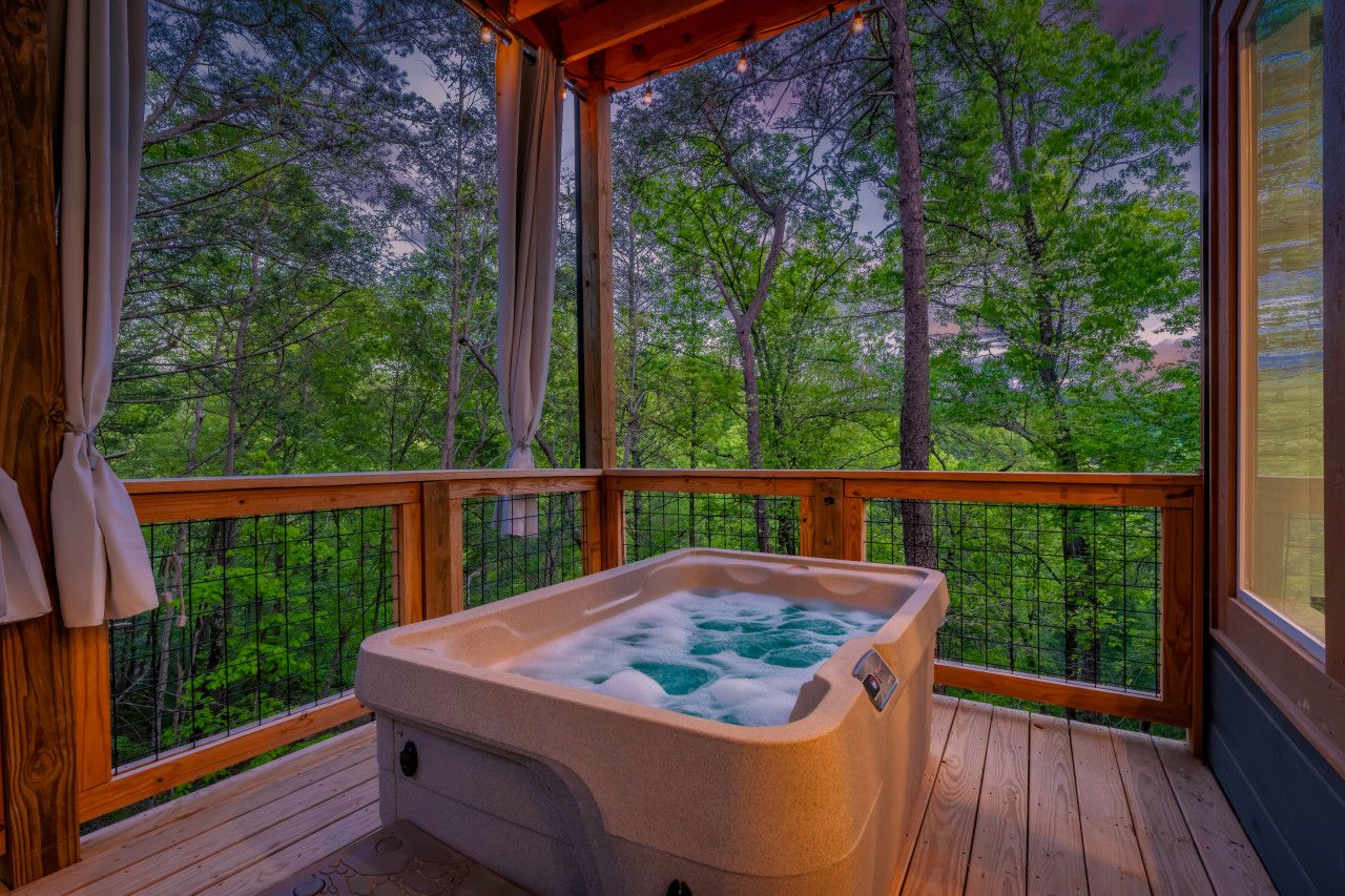 Experience this cabin’s luxurious hot tub nestled in the forest, perfect for a sunset soak.