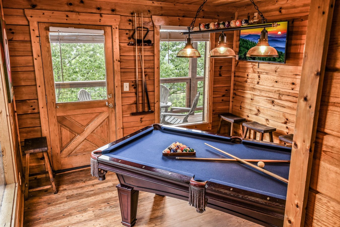 Play pool with a view in this cabin’s game room, framed by huge windows and a big-screen HDTV.