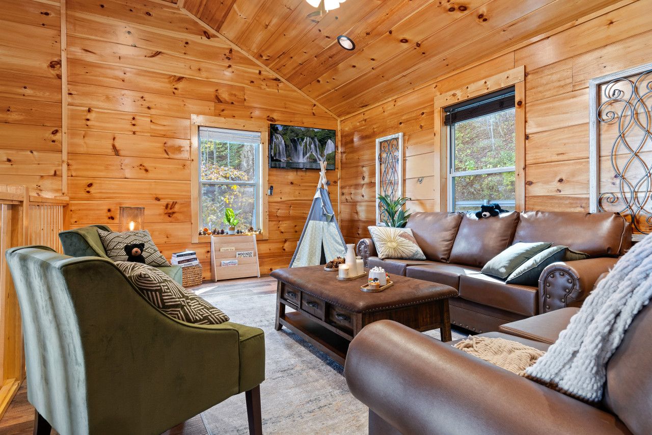 In this cabin, enjoy a spacious living room with plenty of cozy sofas, kid-friendly games, and a perfect space for family fun.
