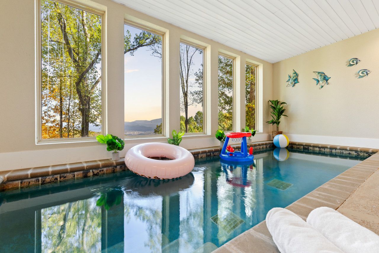 This cabin features a heated pool framed by bay windows, offering Smoky Mountain views and built-in fun for all ages.