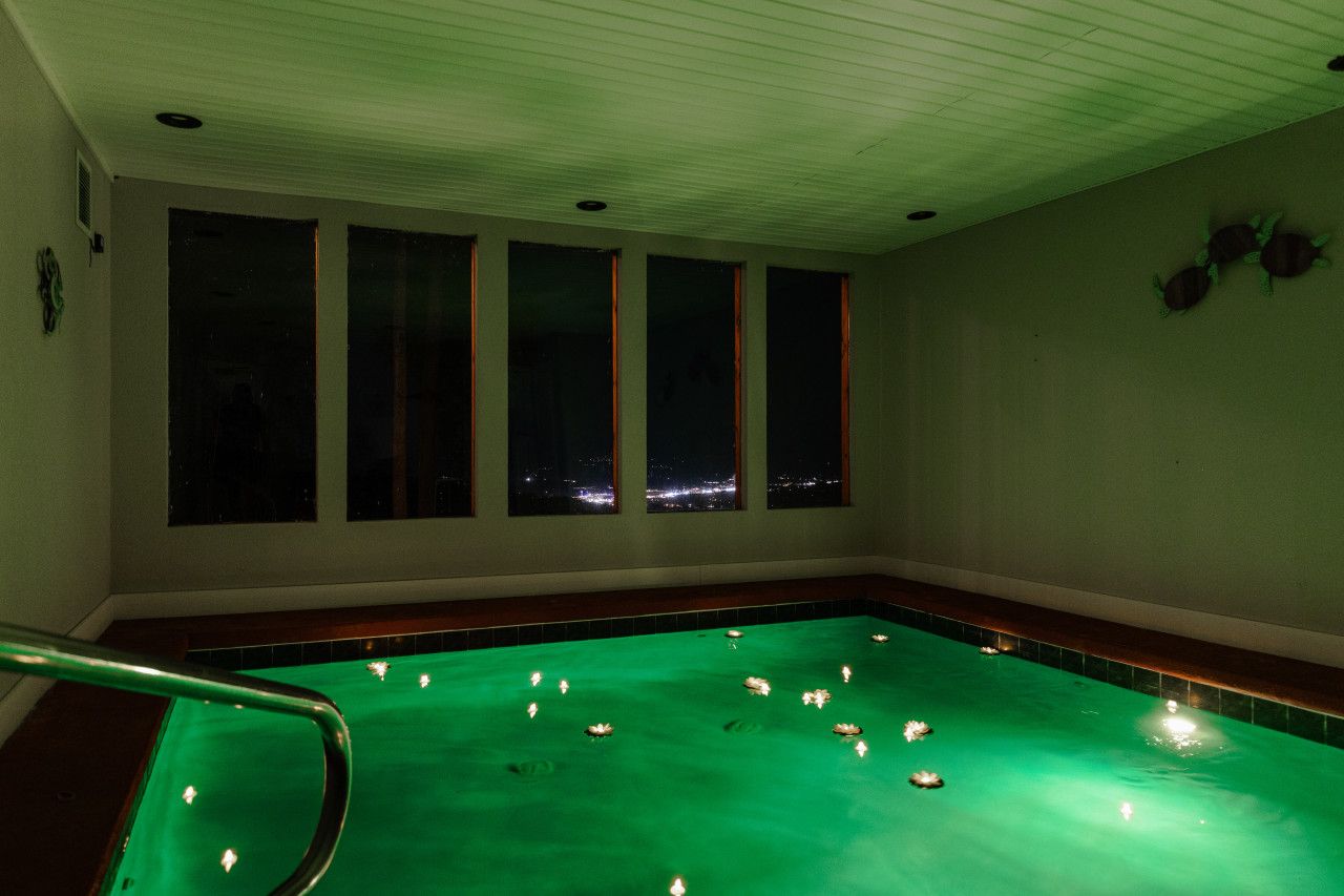 Beneath glowing pool lights, this cabin invites intimate nights with sparkling views of Pigeon Forge—a truly magical escape.