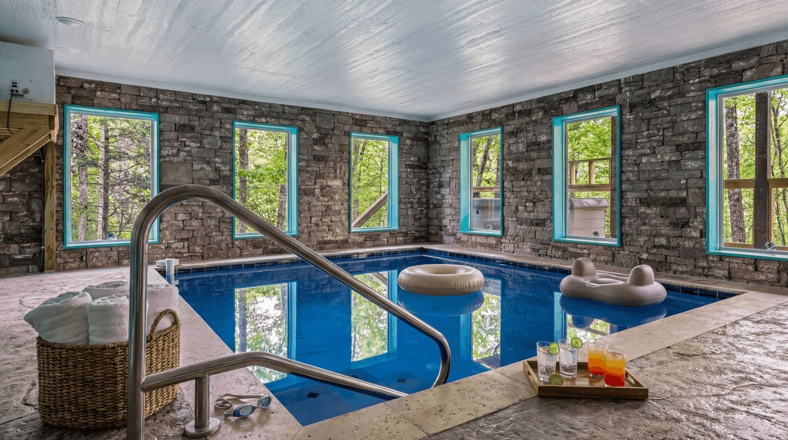 Large indoor pool made for fun — framed by floor-to-ceiling forest views.
