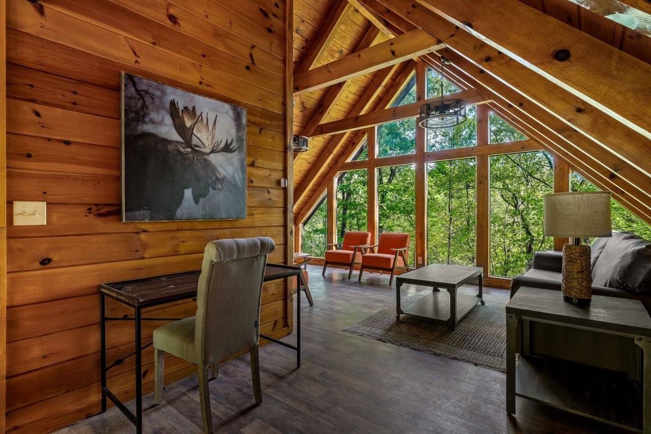 In this cabin, enjoy an immersive nature experience through expansive floor-to-ceiling windows overlooking the forest.