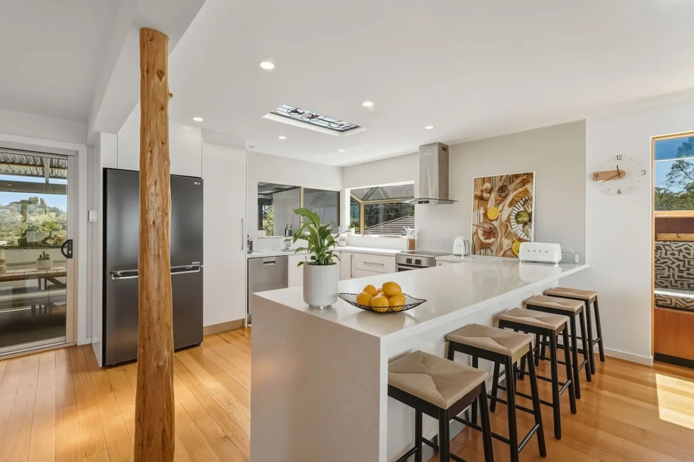 White kitchen with a large island and four stools