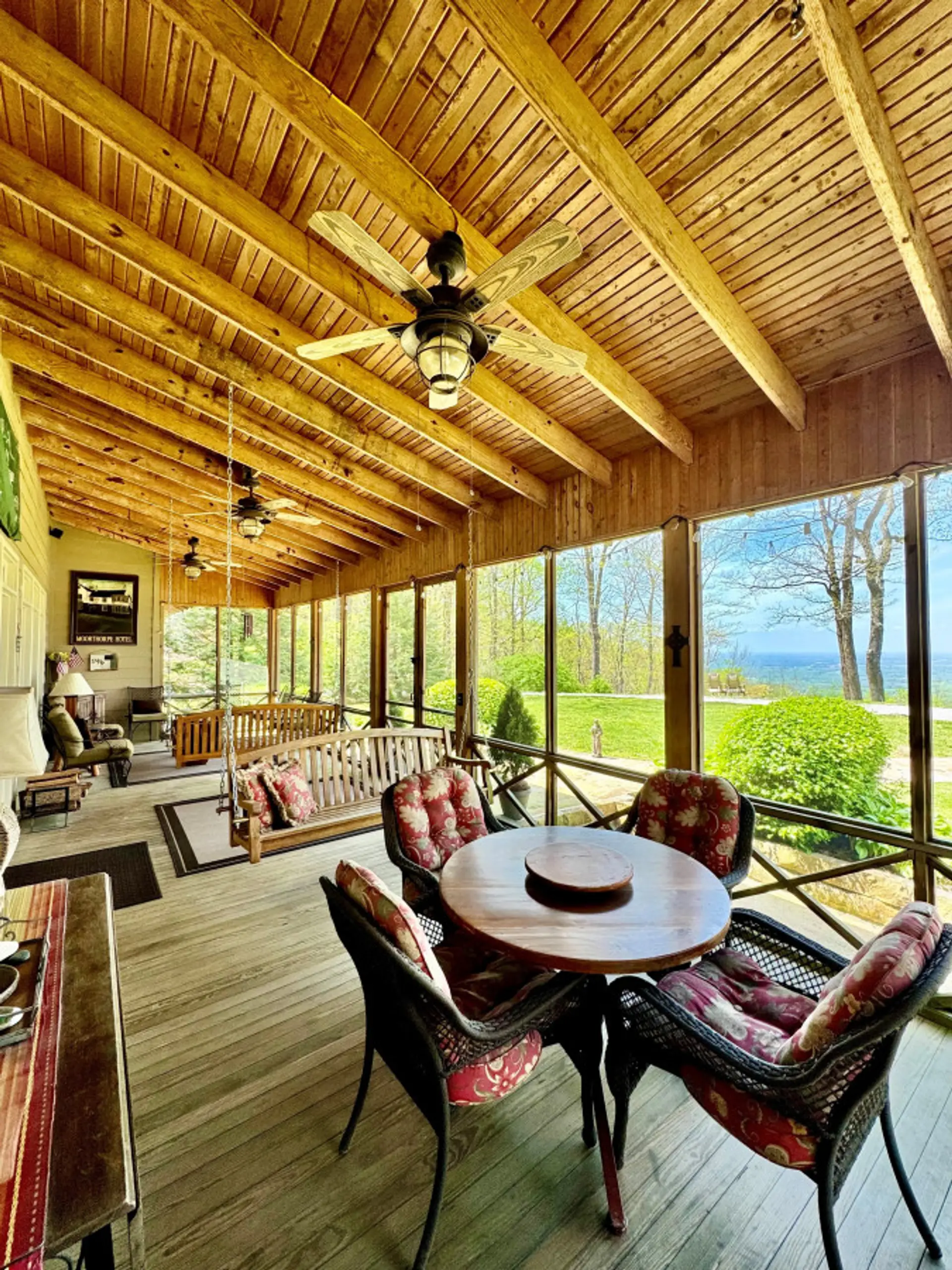 Front porch w/ an incredible view, 3 ceiling fans, and ample seating for 13+ people