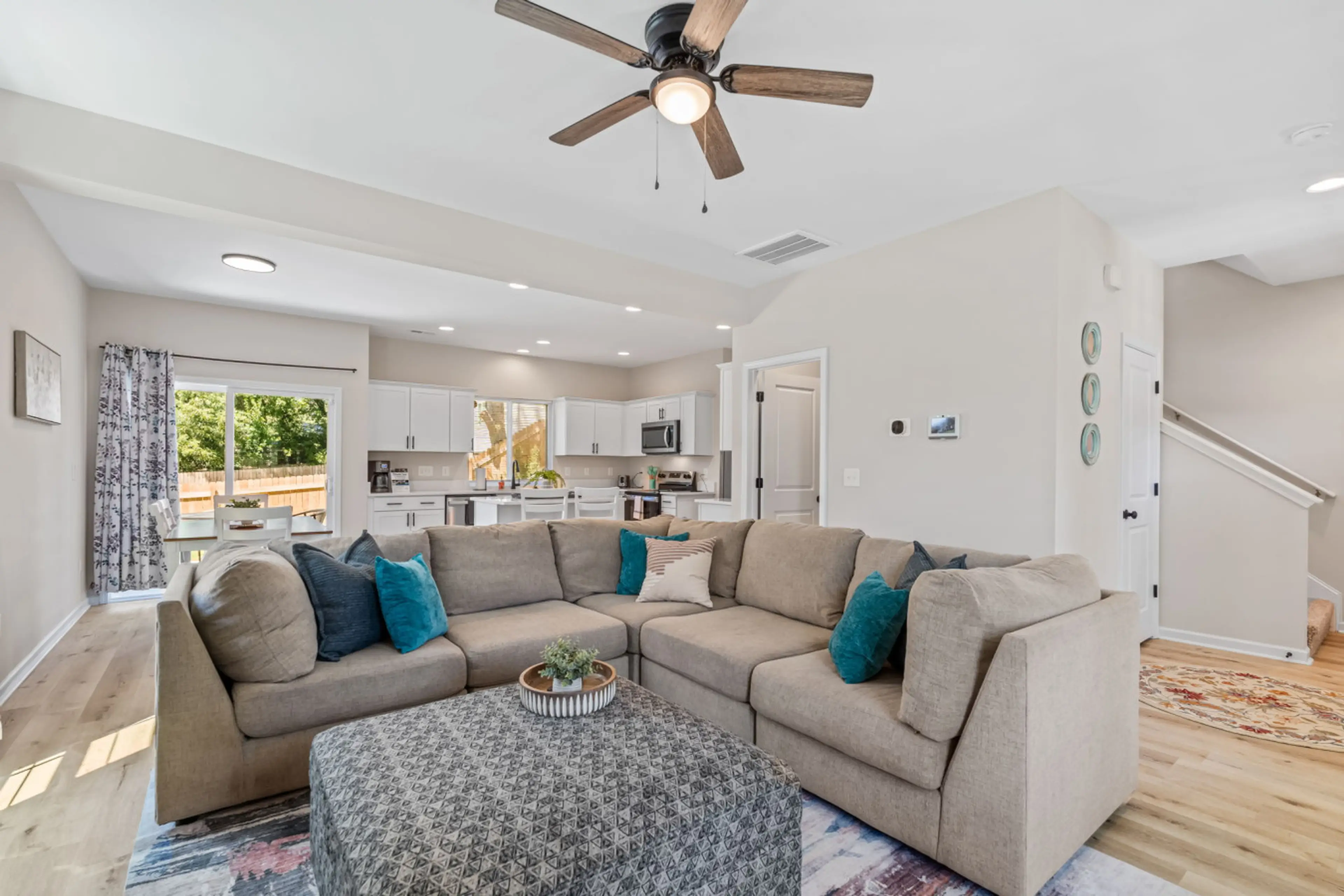 Large living room in the open concept living space downstairs. Includes a large sofa and 65" smart TV.