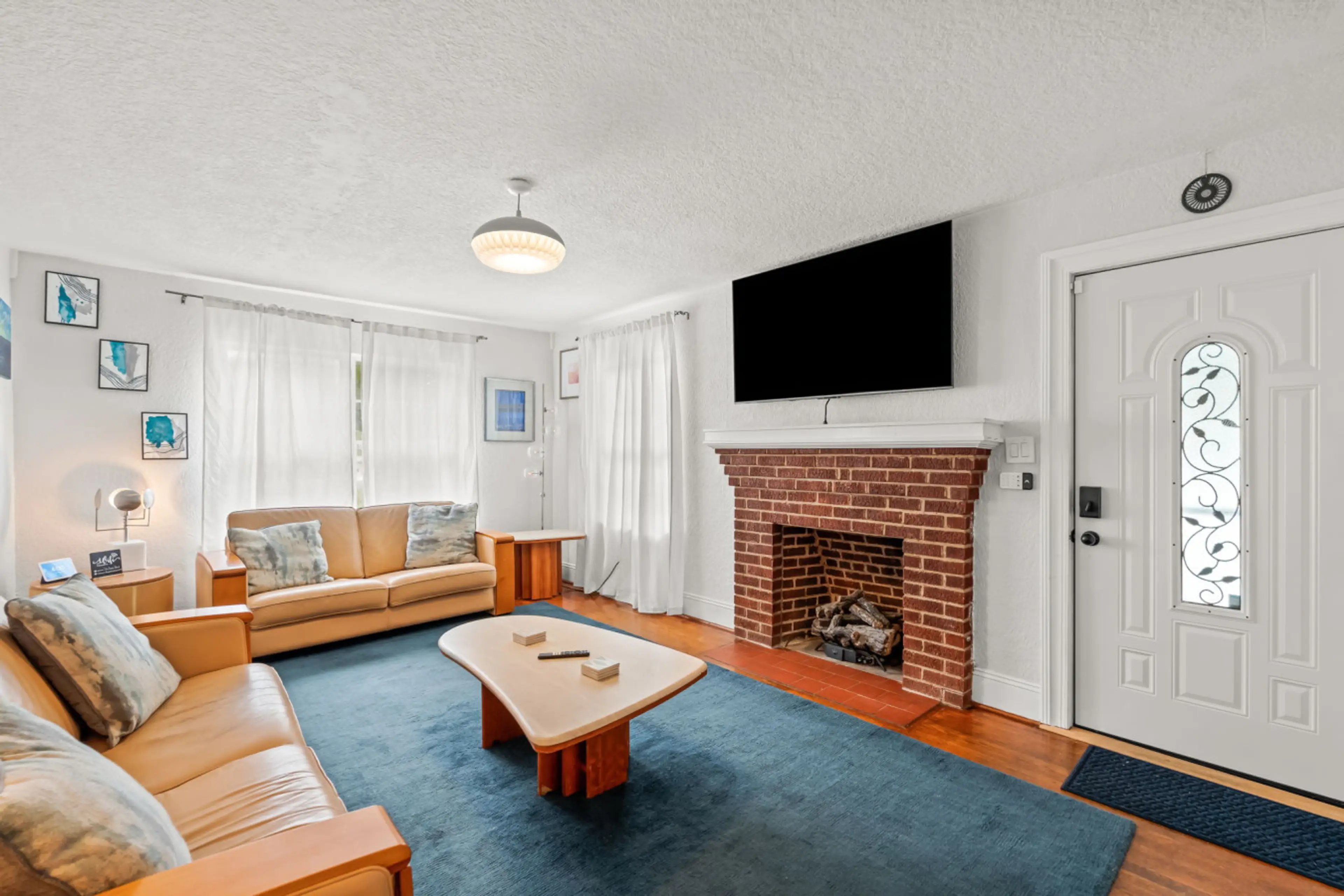 Living room with front entrance and large smart TV.