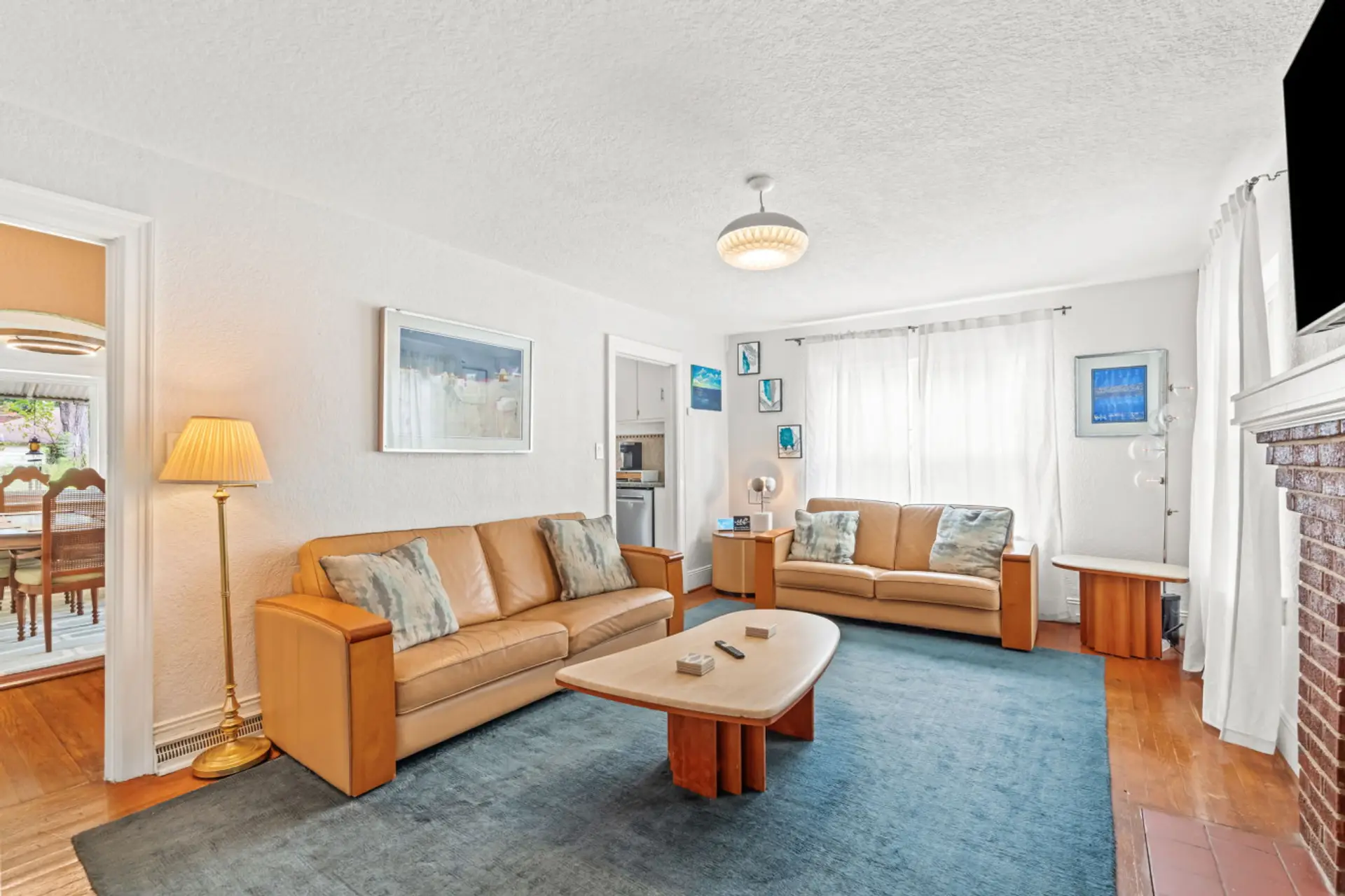 Living room with front entrance and large smart TV.