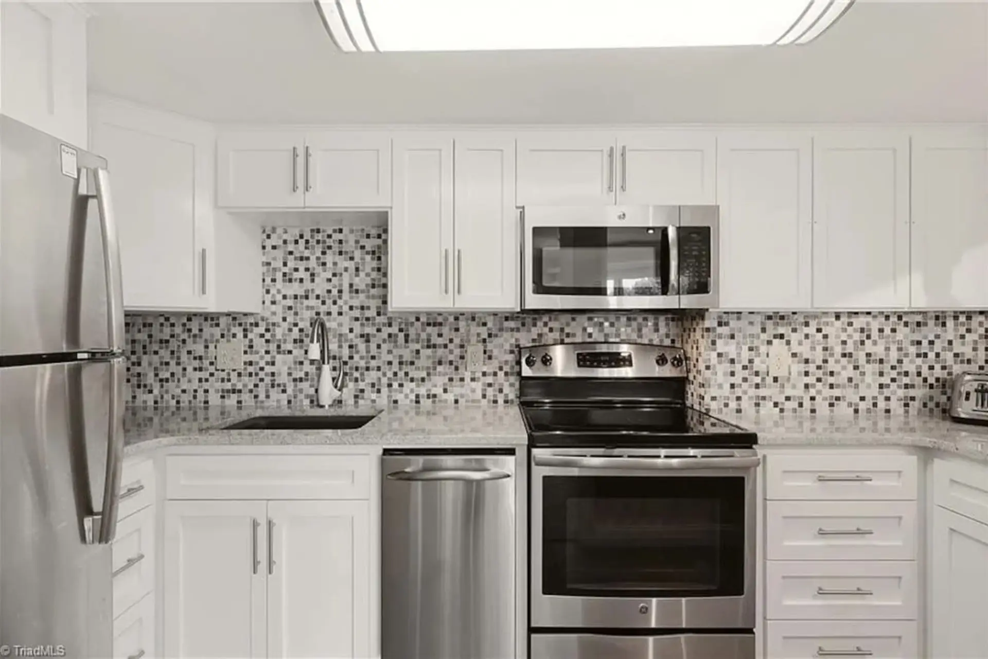 Updated kitchen fully stocked with baking supplies, utensils, plates & silverware, and coffee.