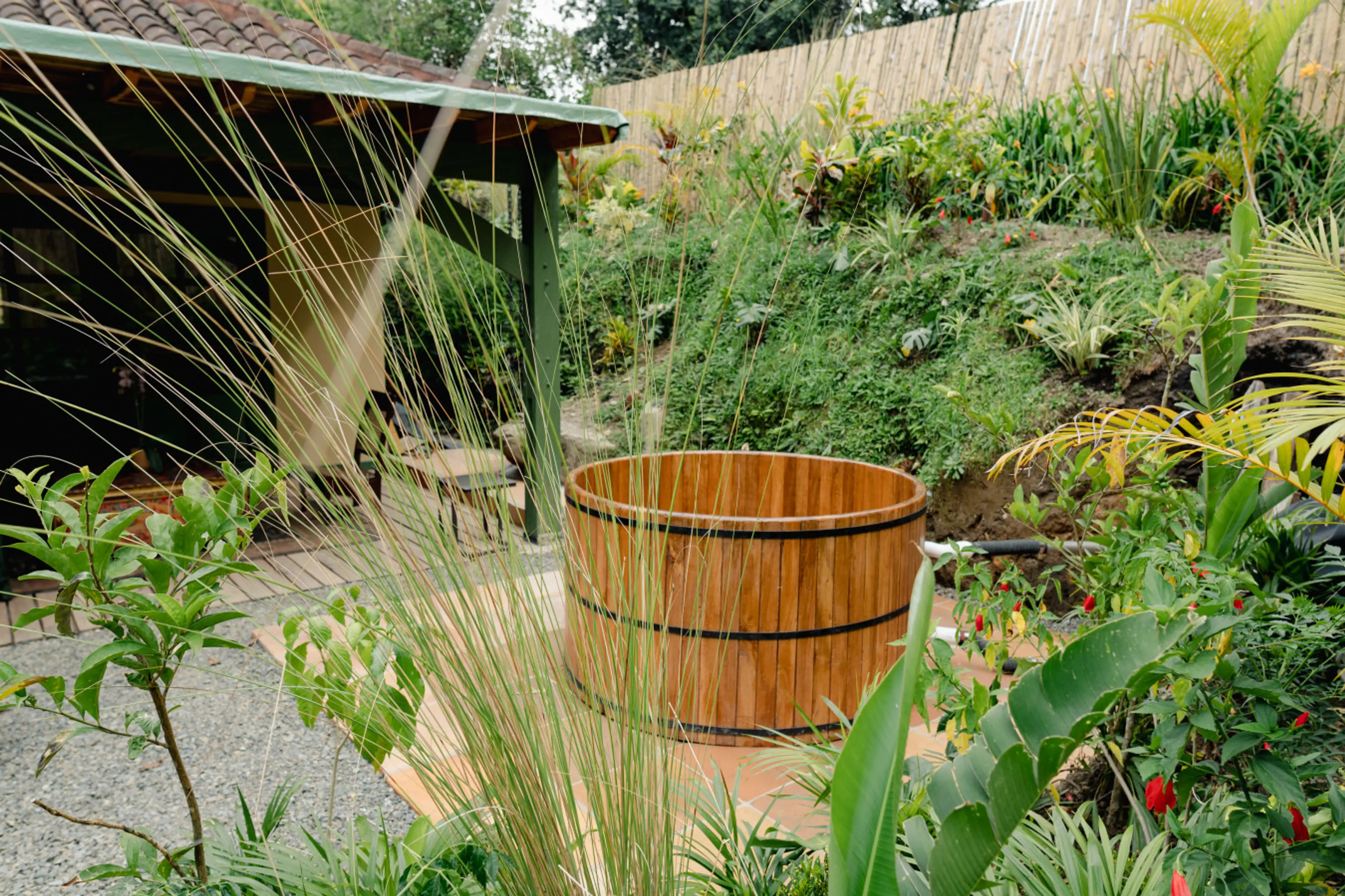 🌿 Escape to paradise with this serene haven surrounded by lush greenery. Bask in the golden sunlight while you soak in the rustic charm of the cedar hot tub. Your peaceful retreat awaits! 🌞✨