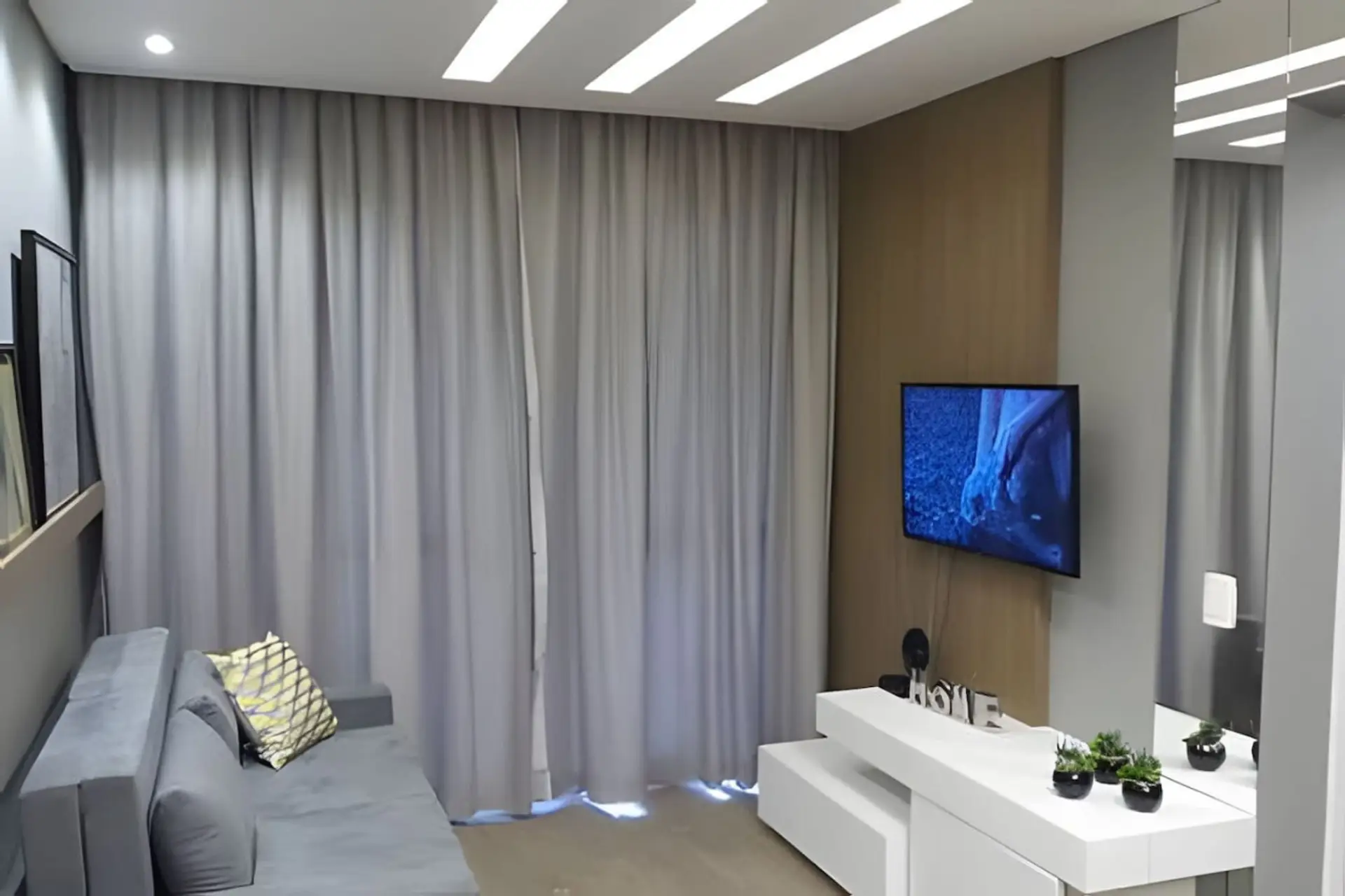 Living com Smart TV,  rack planejado e acesso à varanda