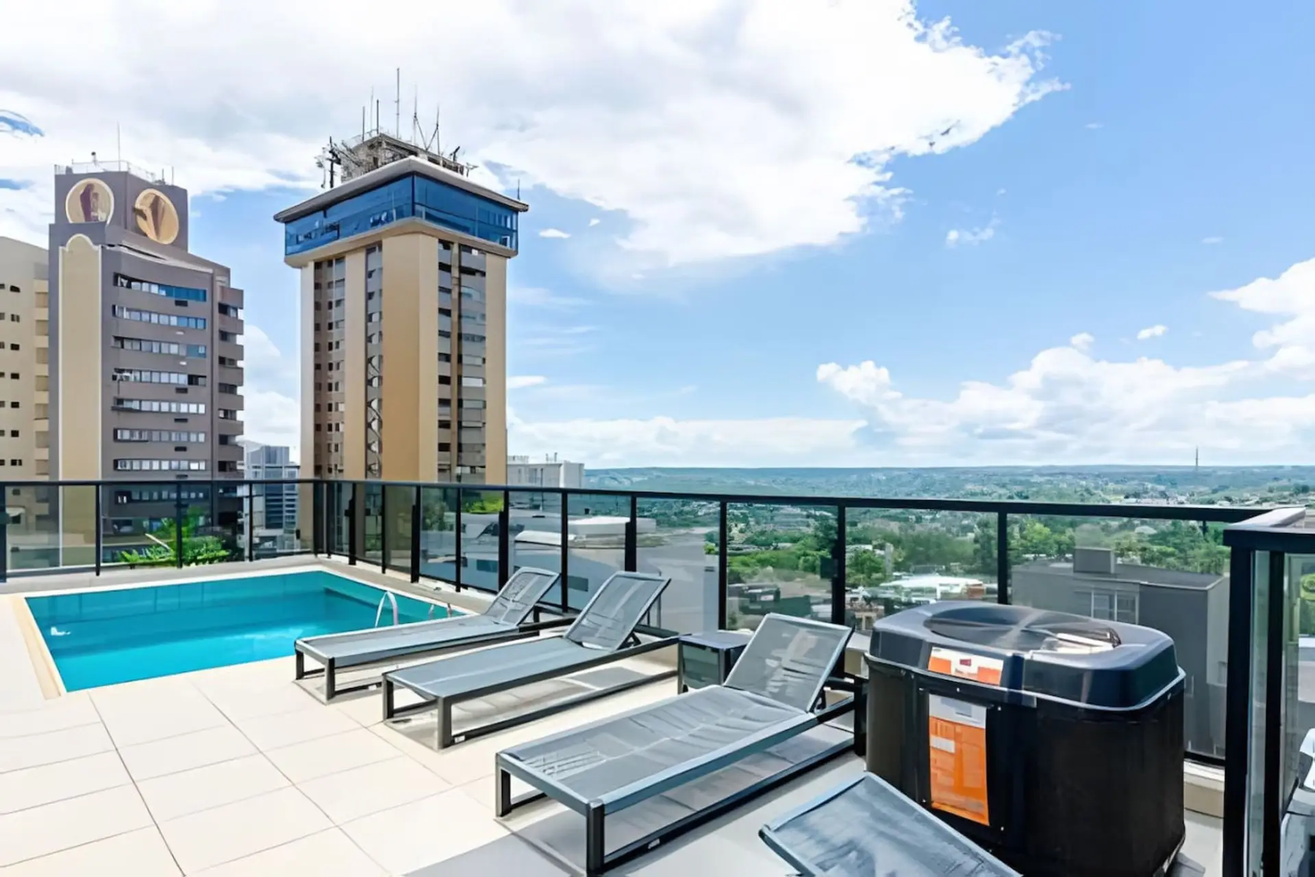 Piscina ao ar livre no rooftop com espreguicadeiras e vista 360° de Curitiba