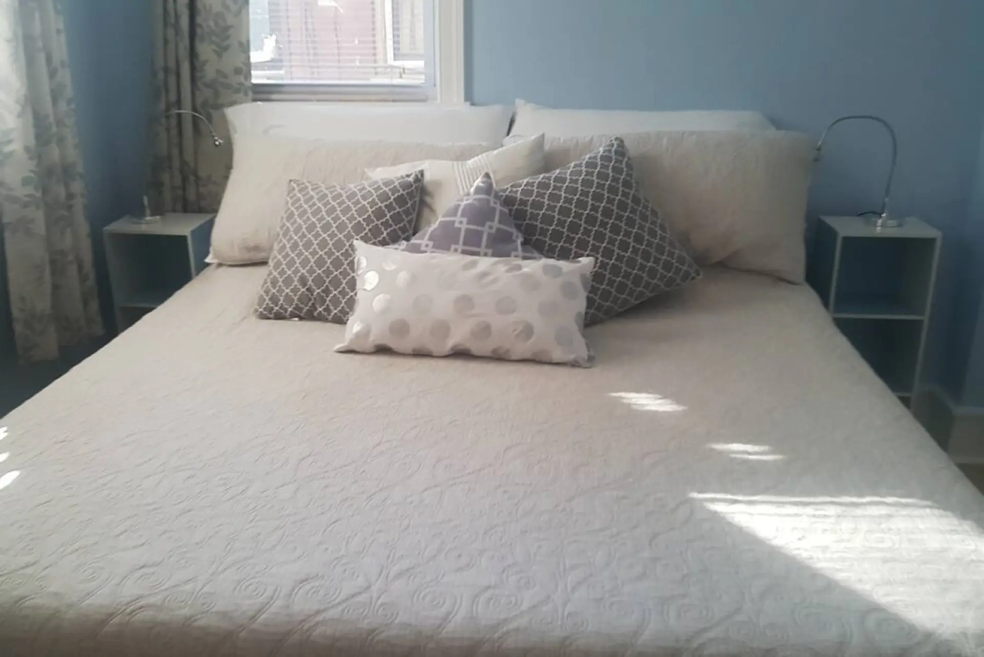 King sized bed with new memory foam mattress, Laura Ashley linens, and room darkening curtains.