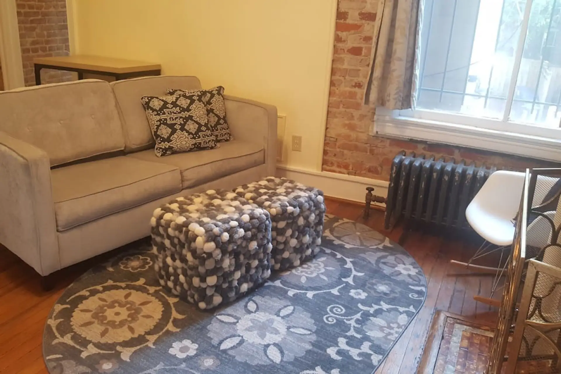 Charming exposed brick, hardwood floors, and over sized windows in the main living area.