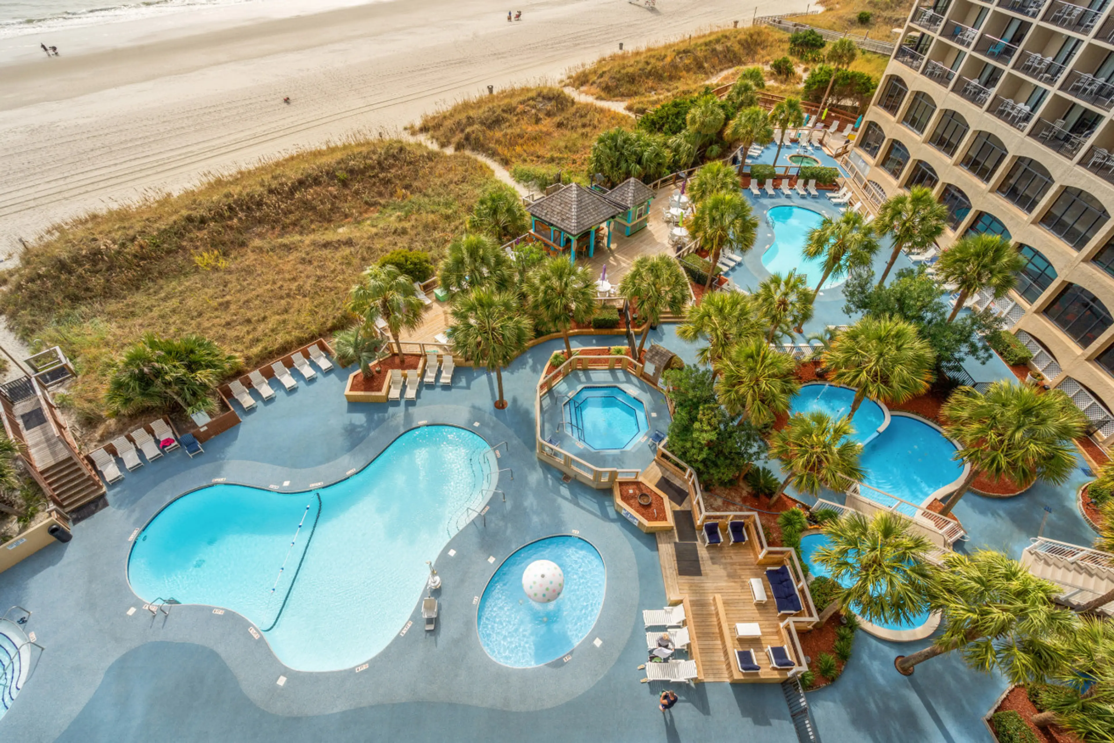 Balcony View of Beach Cove Resort Pools, Hot tubs, Lazy River, Poolside Beach Bar, and Direct Beach Access, and North Myrtle Beach Shoreline