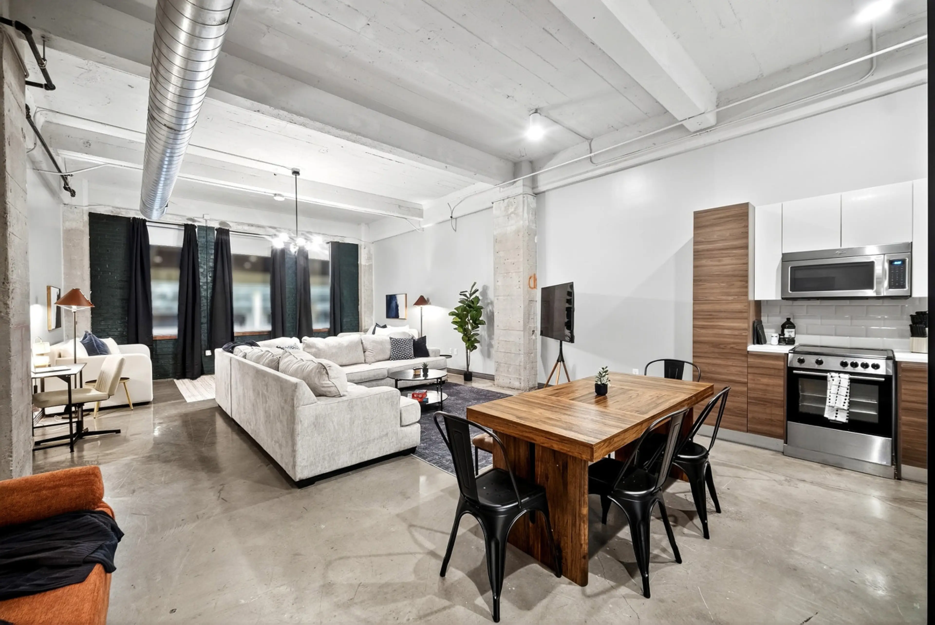 “Loft living” — Experience open-concept living with modern dining, a cozy lounge, and a fully stocked kitchen all in one welcoming space