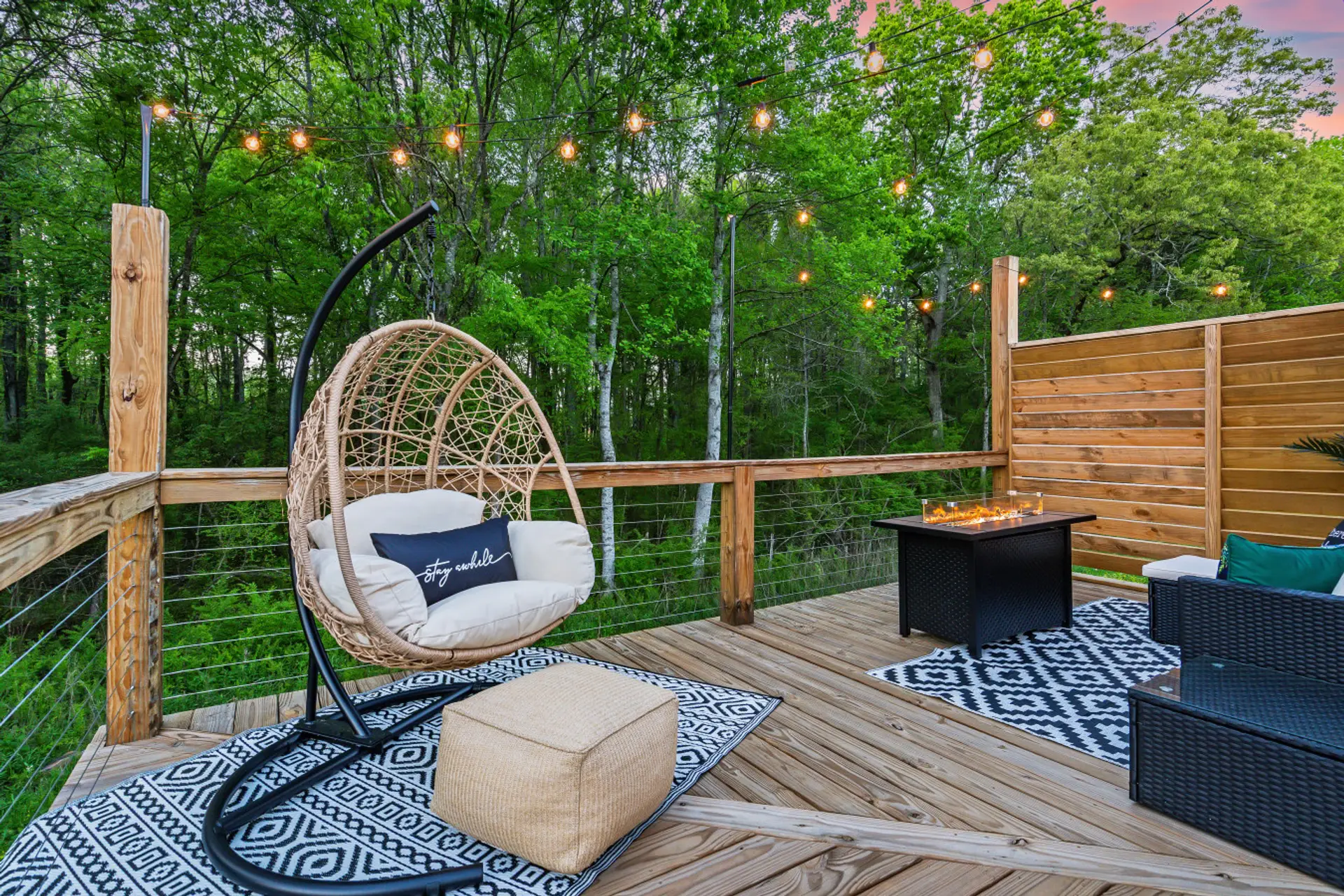 Private forest-view deck with cozy seating, café lights, and peaceful nature all around.