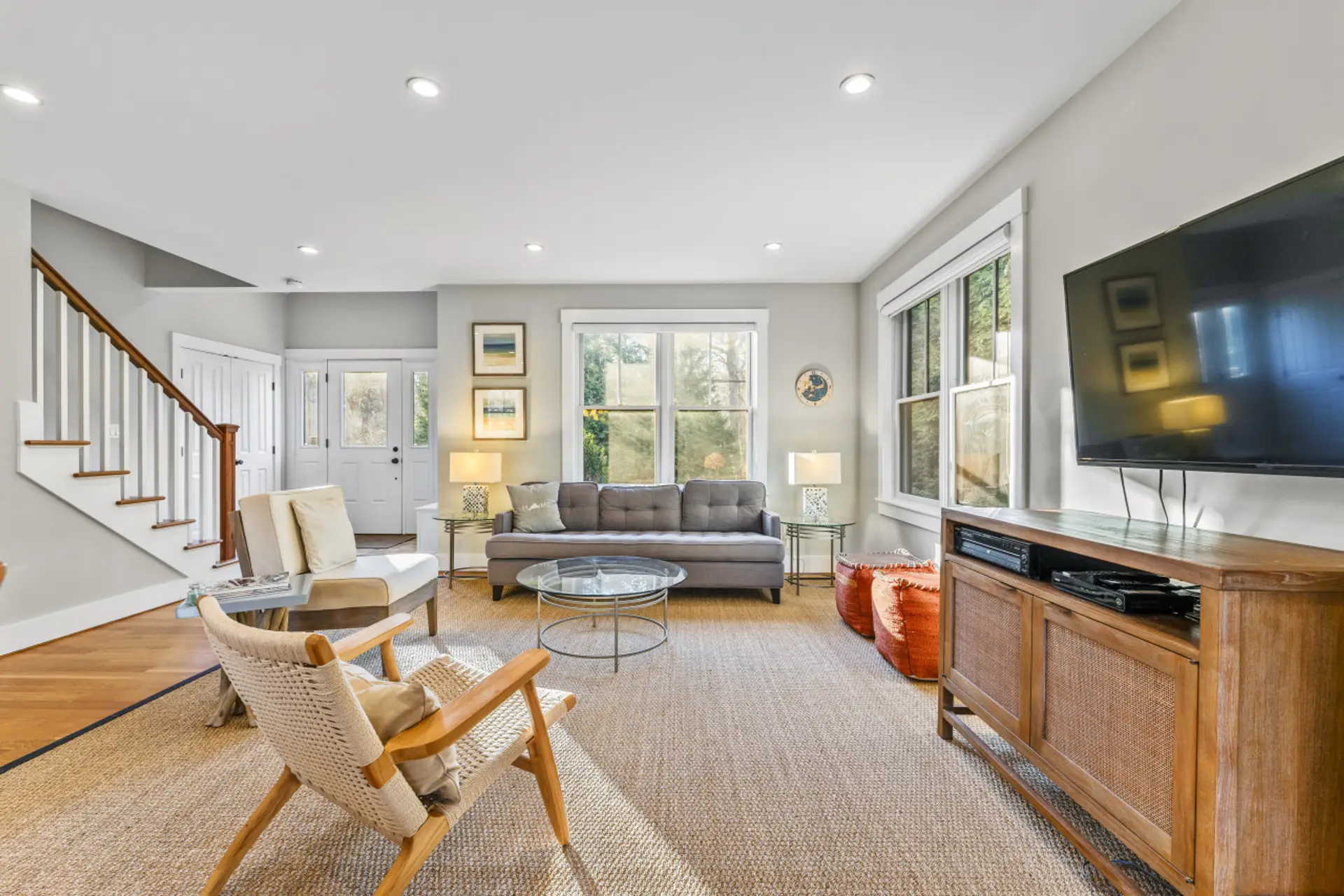 The living room offers a serene ambiance, enhanced by an abundance of natural light pouring in from the outside.