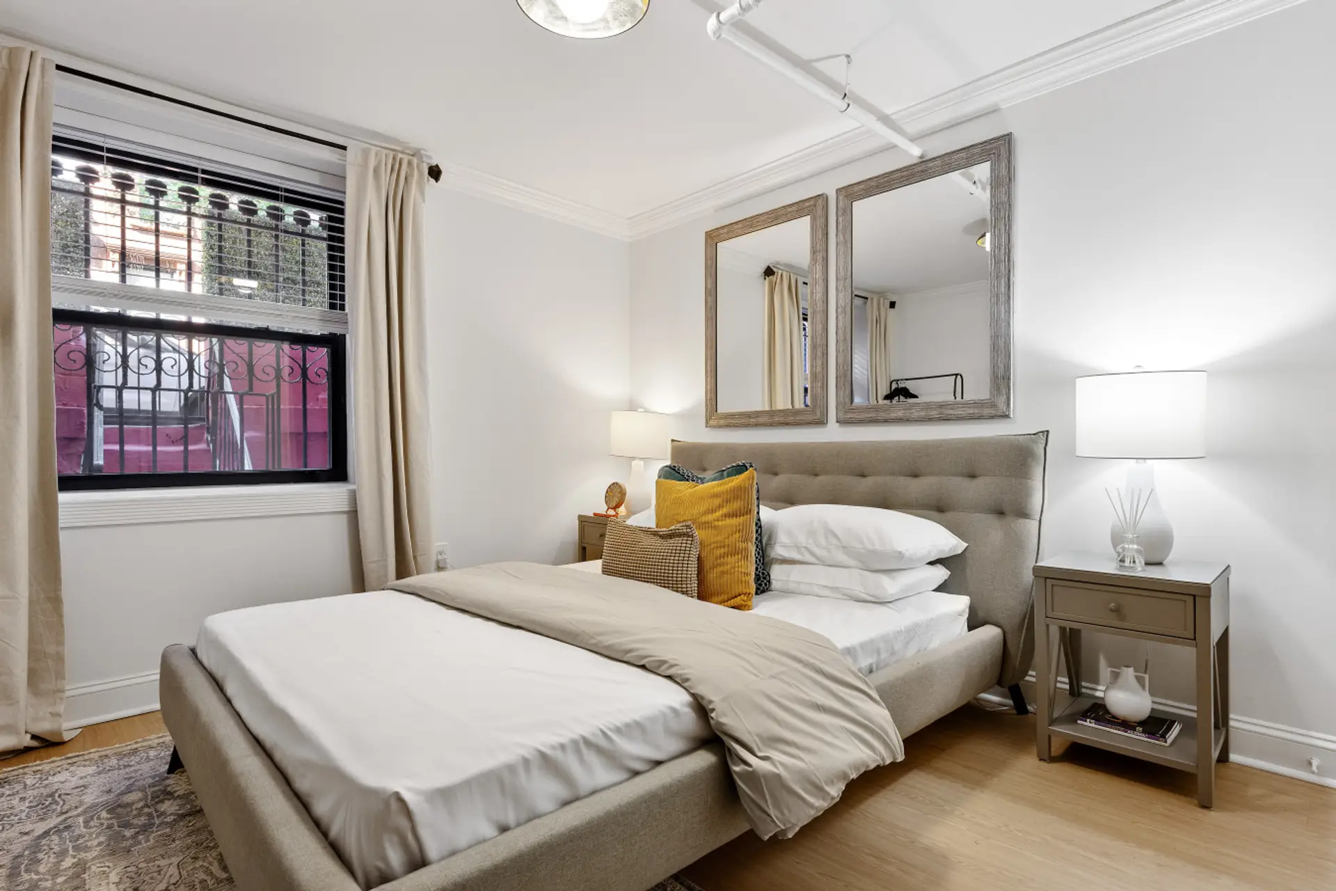 Imagine waking up to the gentle sunlight streaming through a large window, illuminating a comfortable bed accented with sparkling mirrors. This room offers a peaceful retreat, complete with a bedside lamp for those quiet evenings.