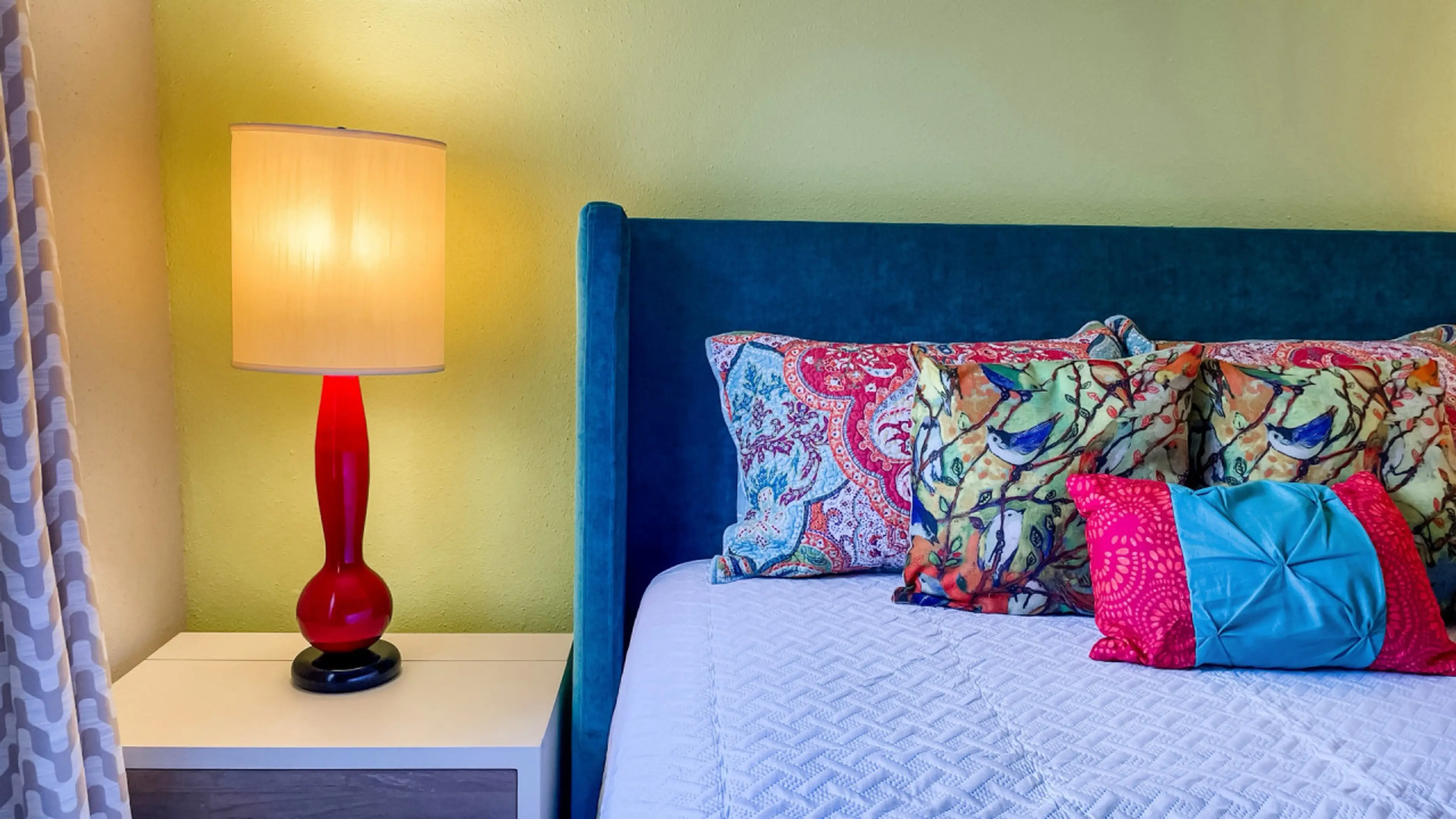 Close-up of the cozy bed in the bedroom, featuring a stylish side lamp.