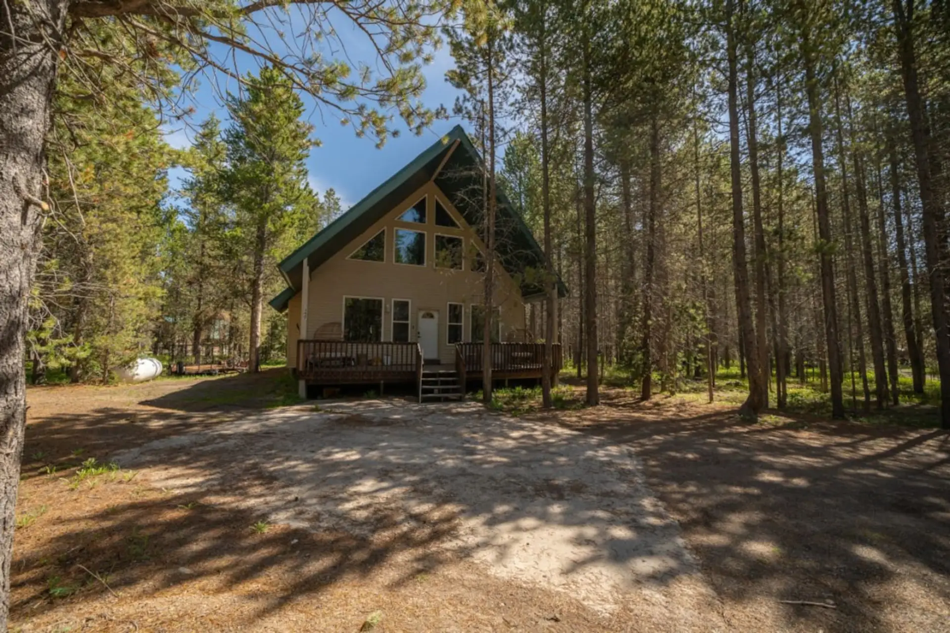 Front exterior of cabin – surrounded by pines with huge deck