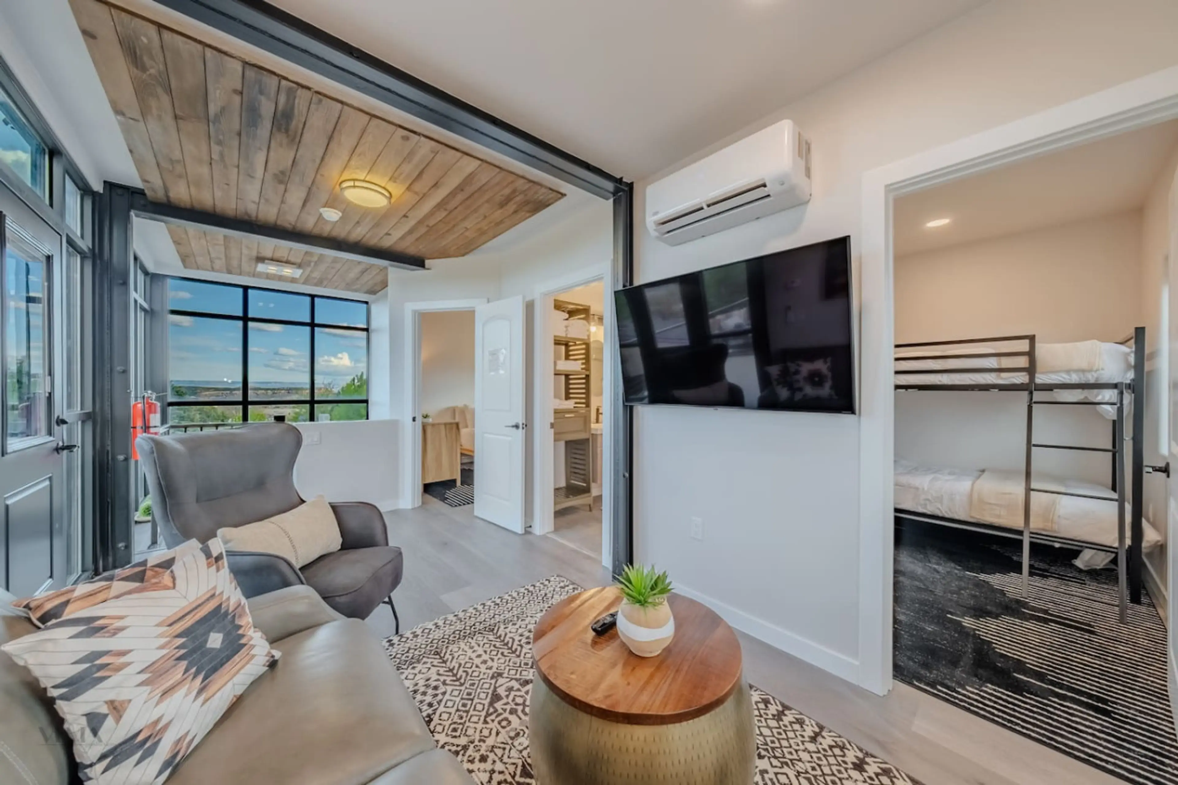Modern living area with seating, TV, and bunk beds.