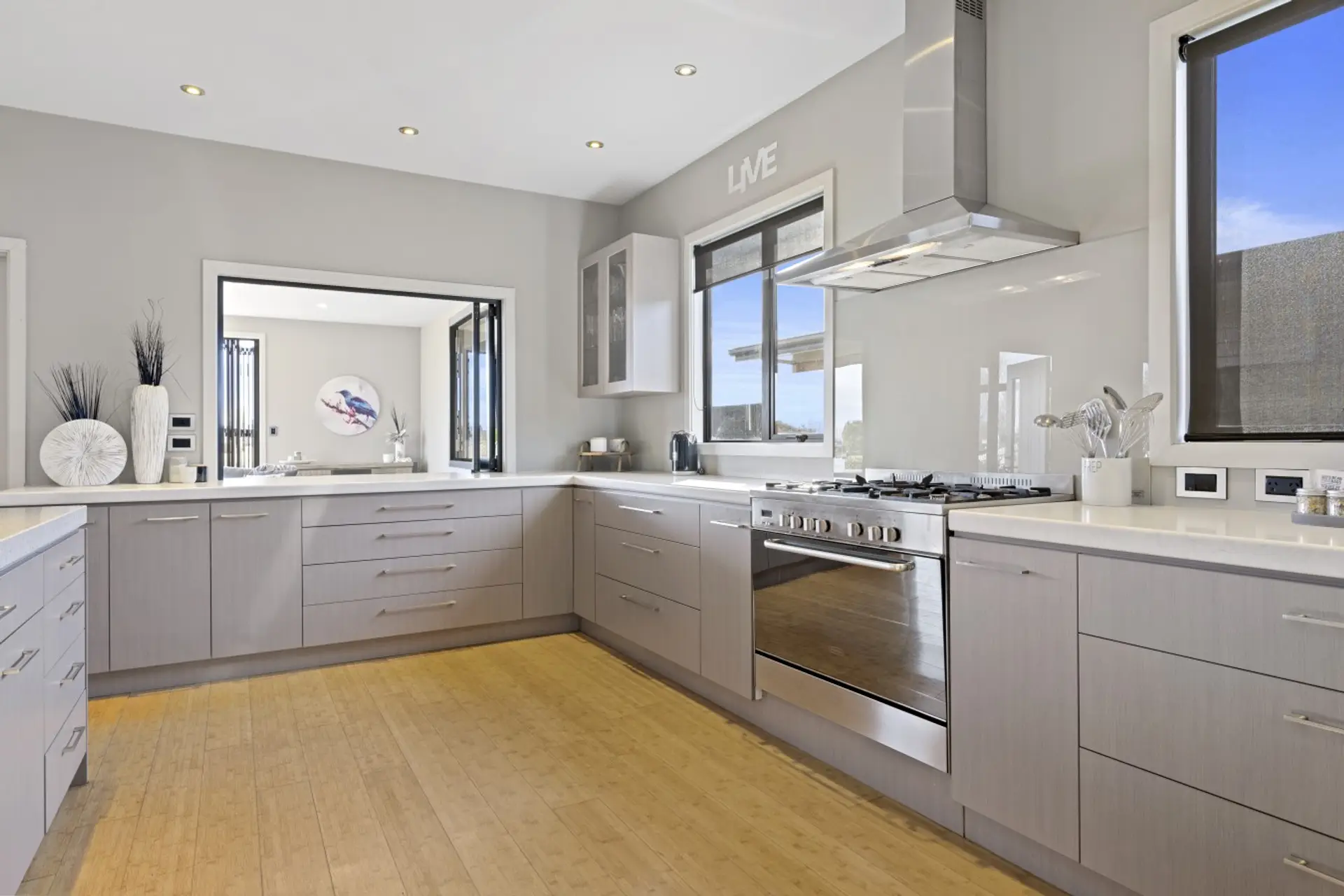 A generously designed open-plan kitchen, elegantly equipped with an oven, fridge, freezer, dishwasher, and a complete set of kitchen utensils and cutlery.