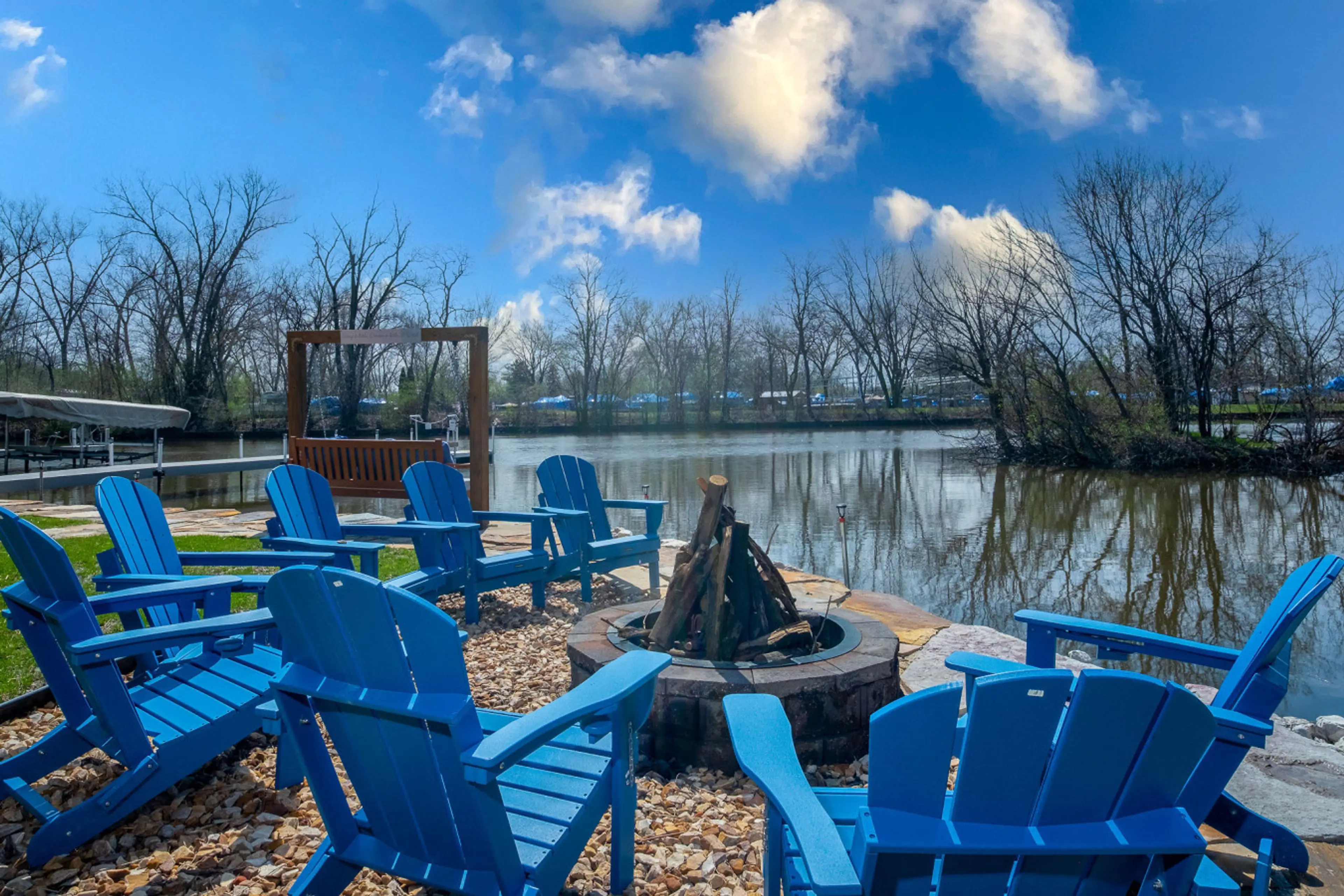 Huge Fire pit area with plenty of chairs surrounded by waterfront