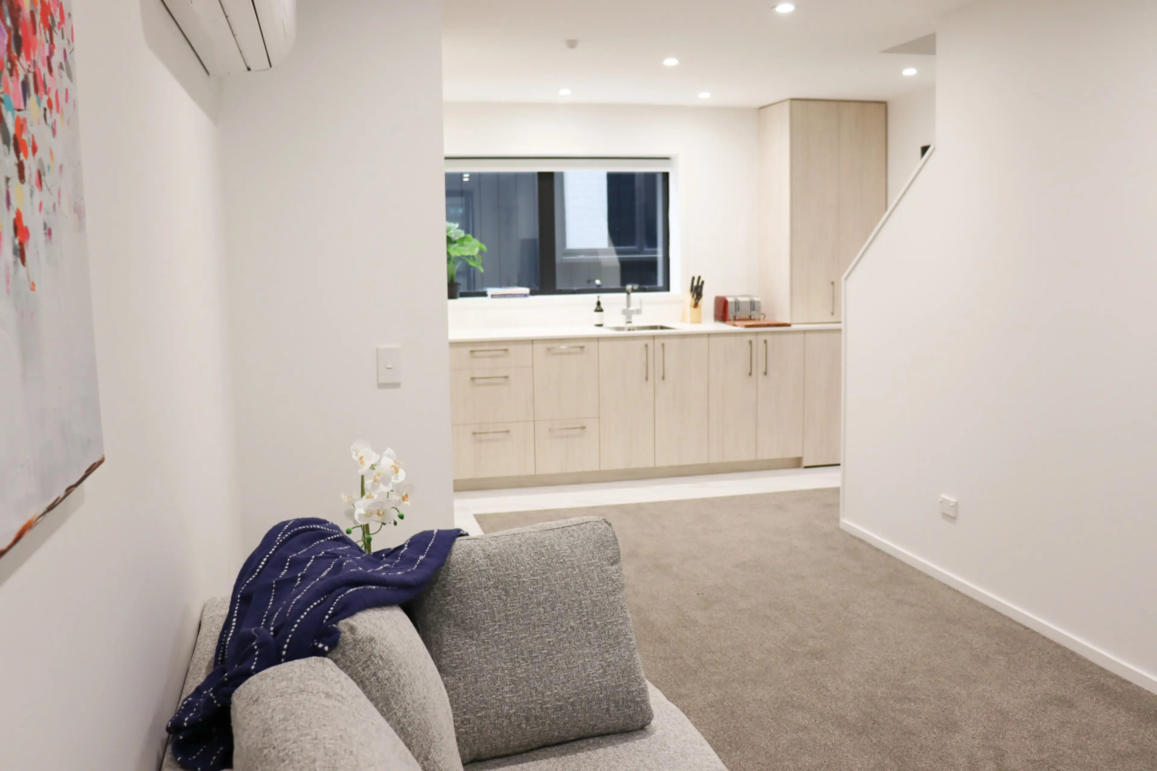 Spacious living area with a cozy sofa, stylish decor, and plenty of natural light—ideal for relaxing and unwinding.