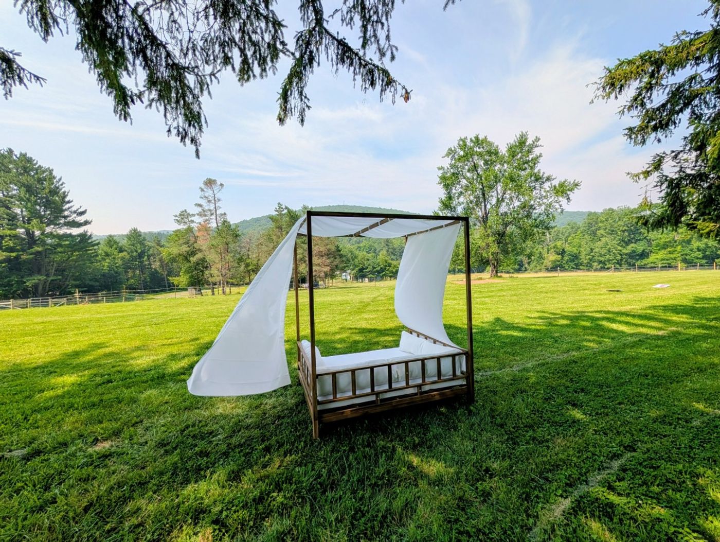 Canopy daybed with white curtains on the lawn