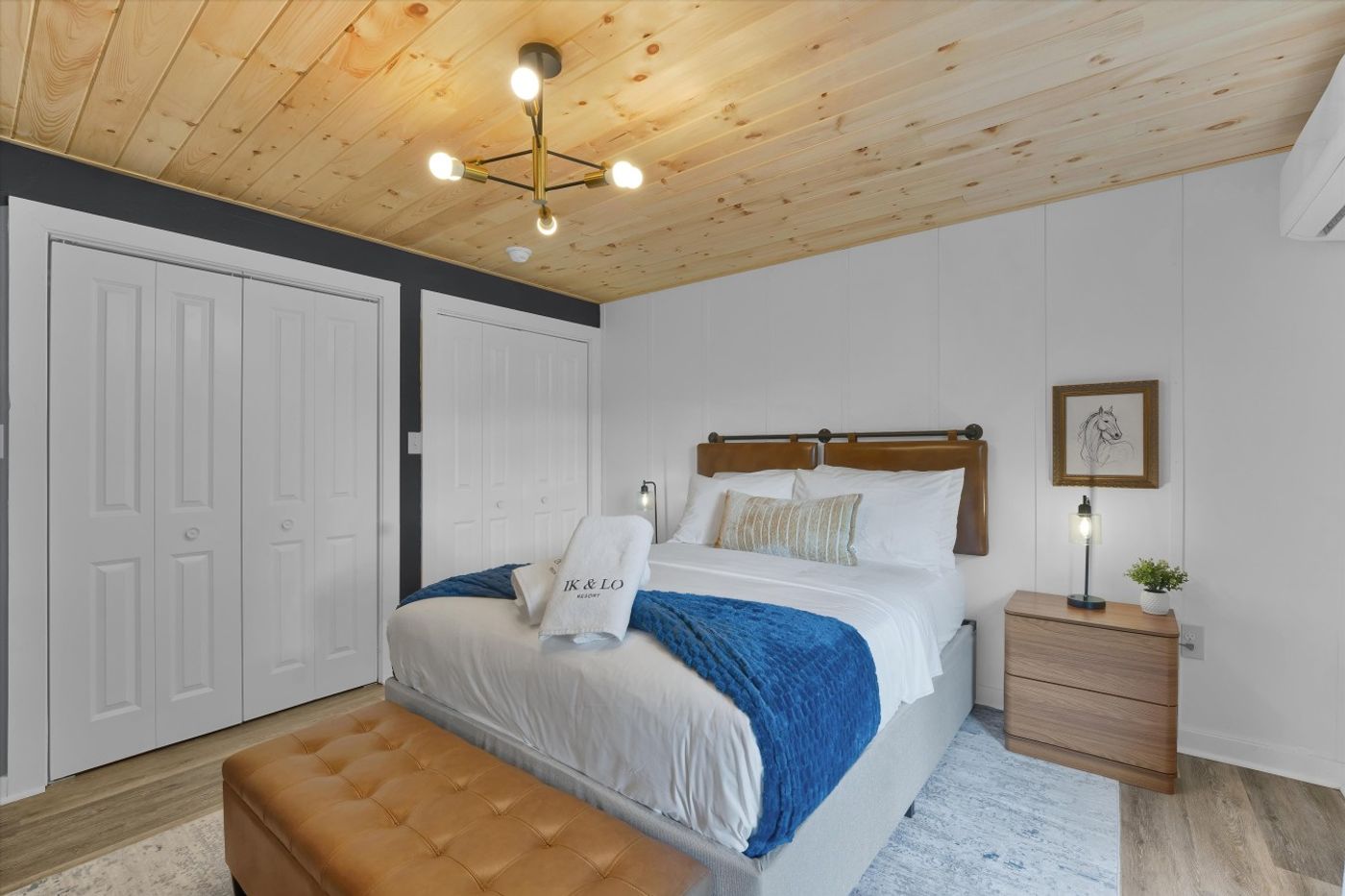 Bedroom with a blue throw on the bed and wood ceiling