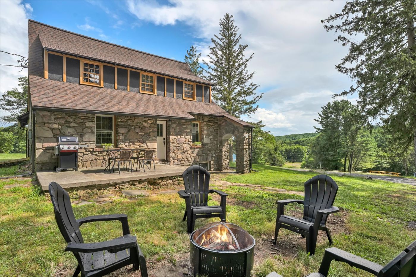 Two-story house with Adirondack chairs on the lawn