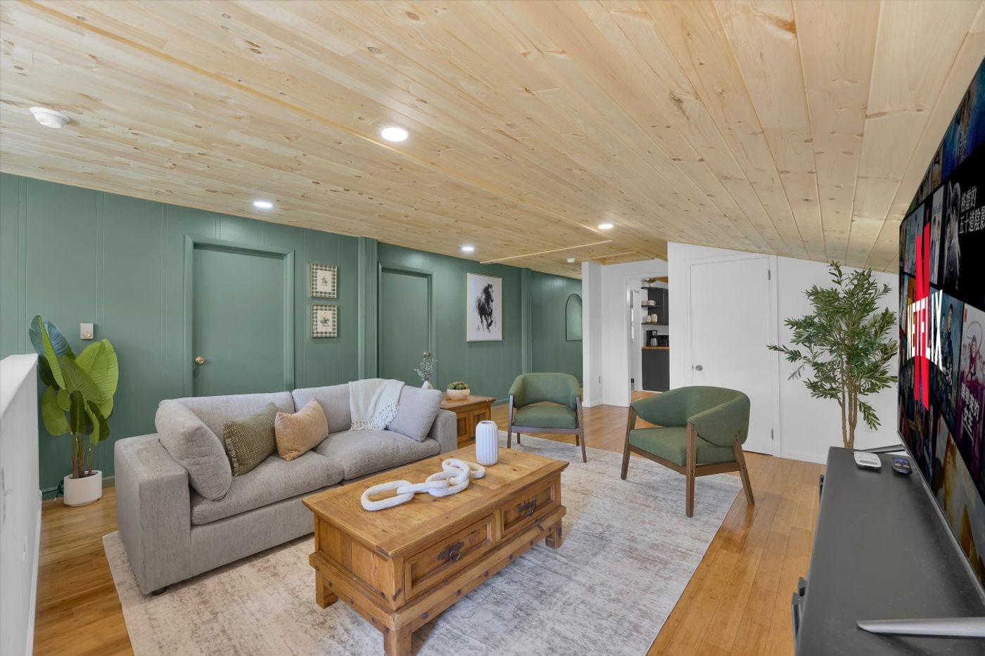 Living room with grey sofas and a green accent wall
