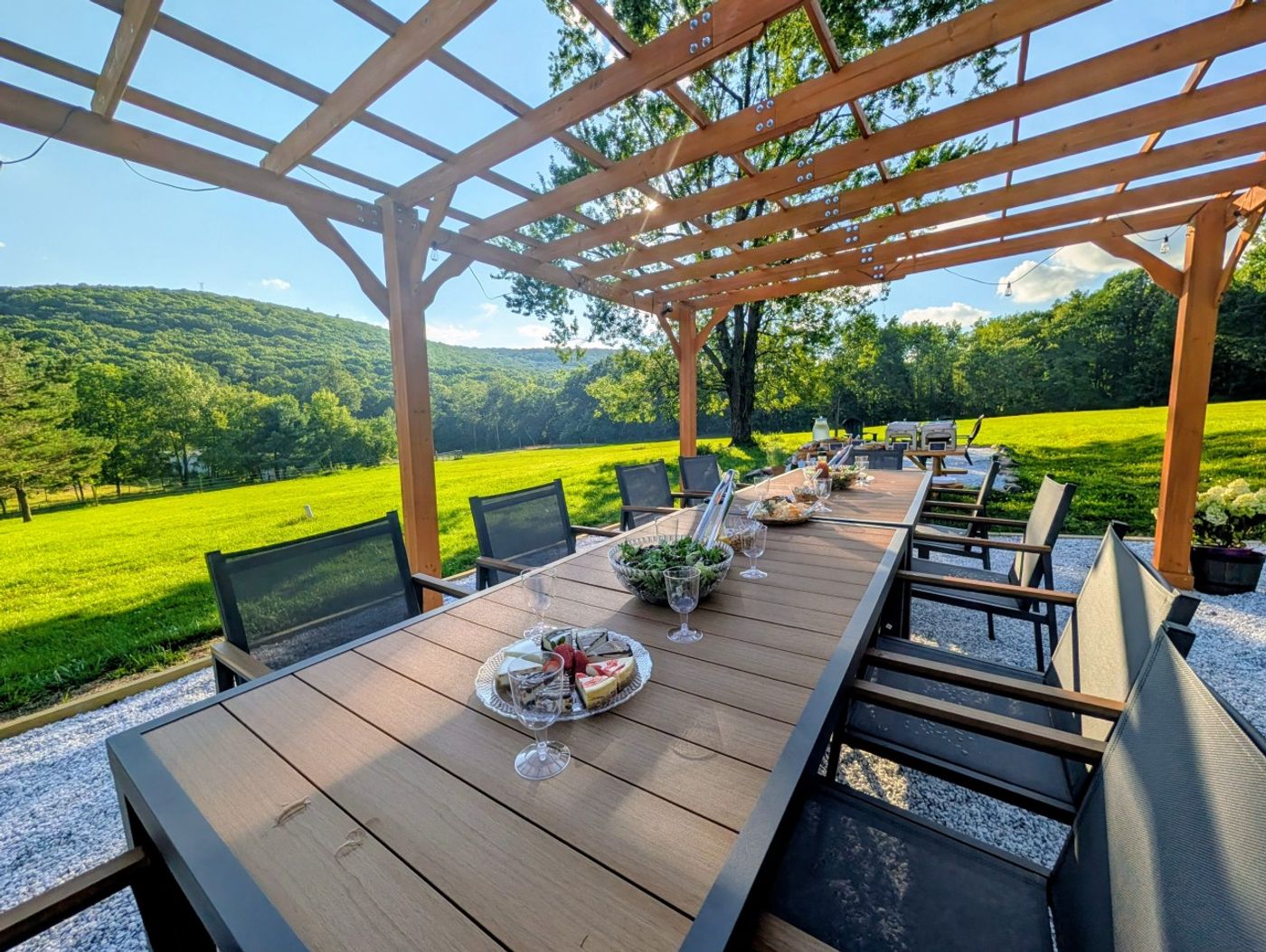 Long dinner table under the pergola with a mountain view