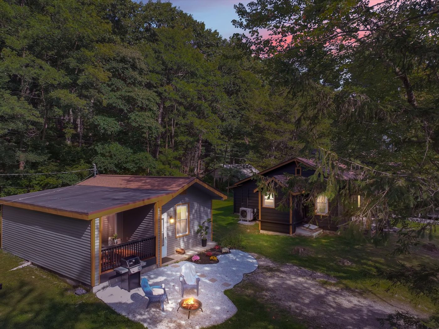 The cottage glowing at twilight among the trees