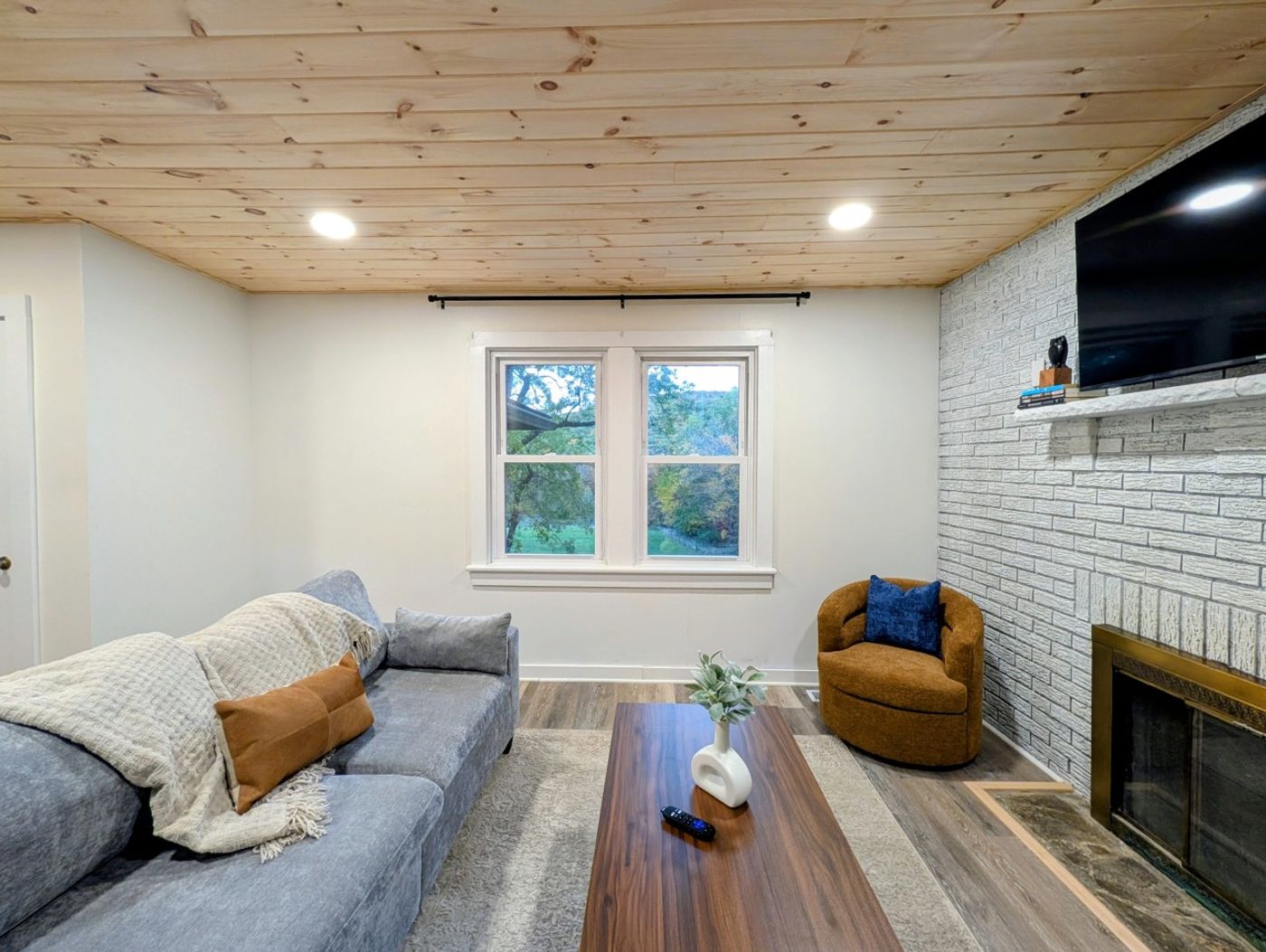 Living room with sofa, armchairs and wood ceiling