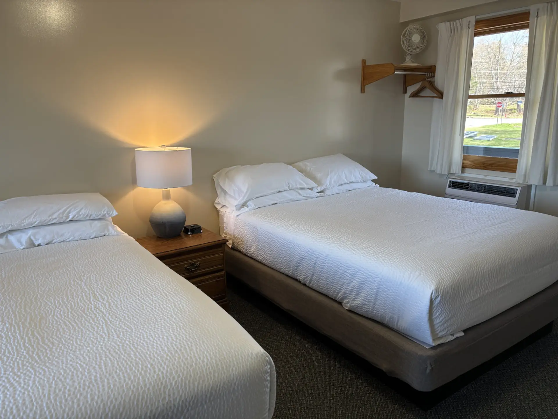 Bright bedroom with two queen beds, crisp linens, and natural light for a comfortable stay.