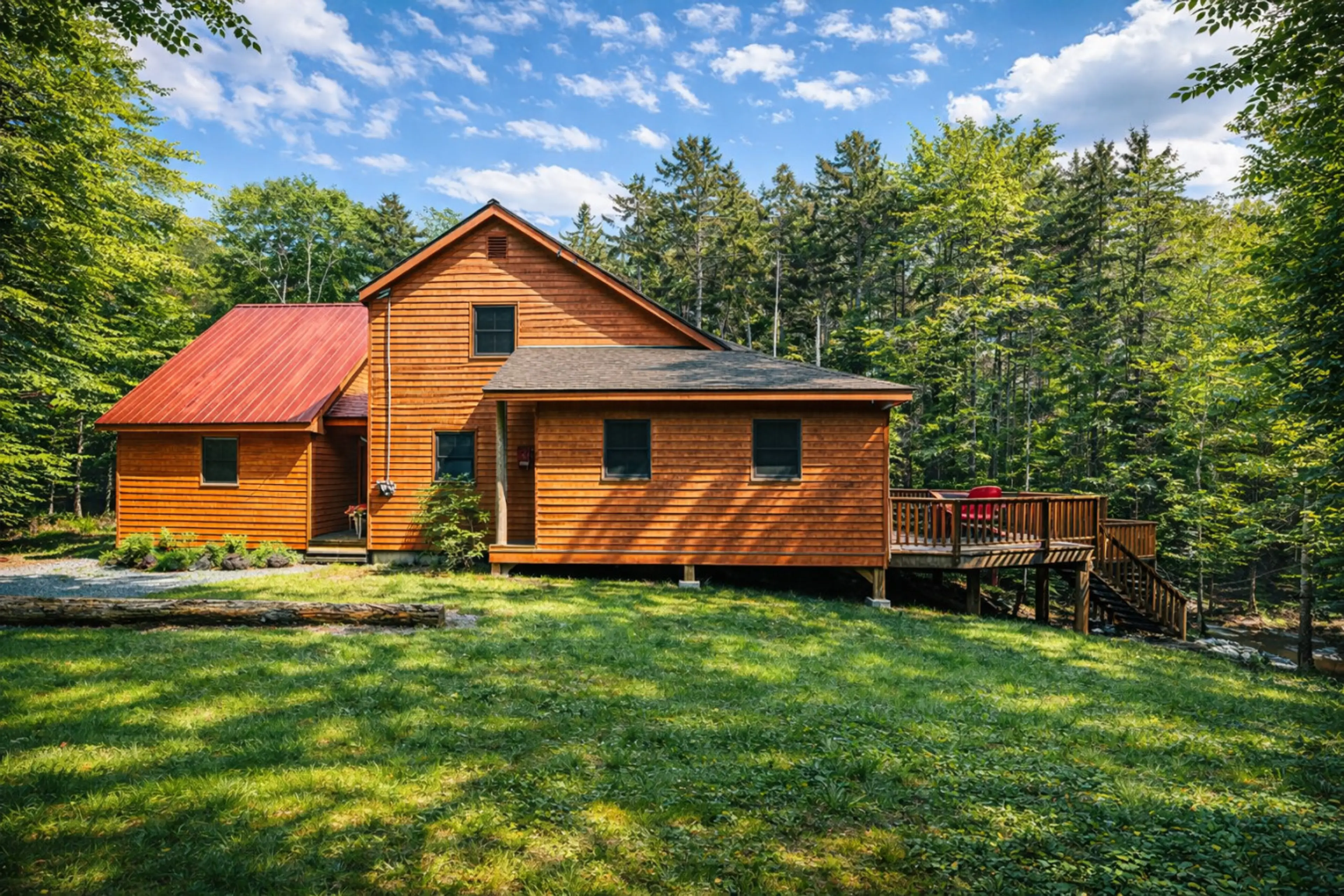 Spacious woodland retreat with a large private deck, expansive lawn, and peaceful forest surroundings perfect for a relaxing getaway.