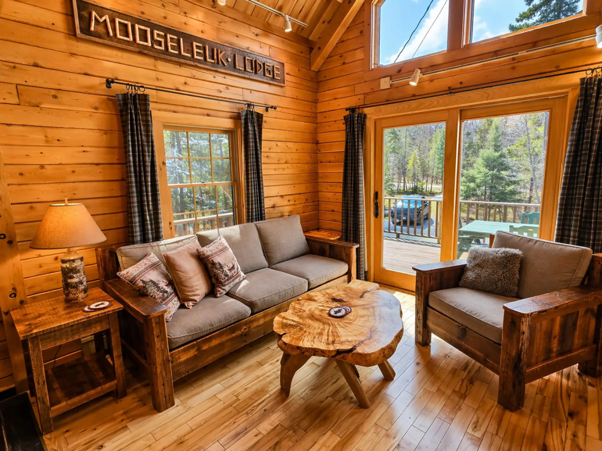 Cozy log cabin living room with soaring ceilings, rustic wood interiors, and peaceful forest views.
