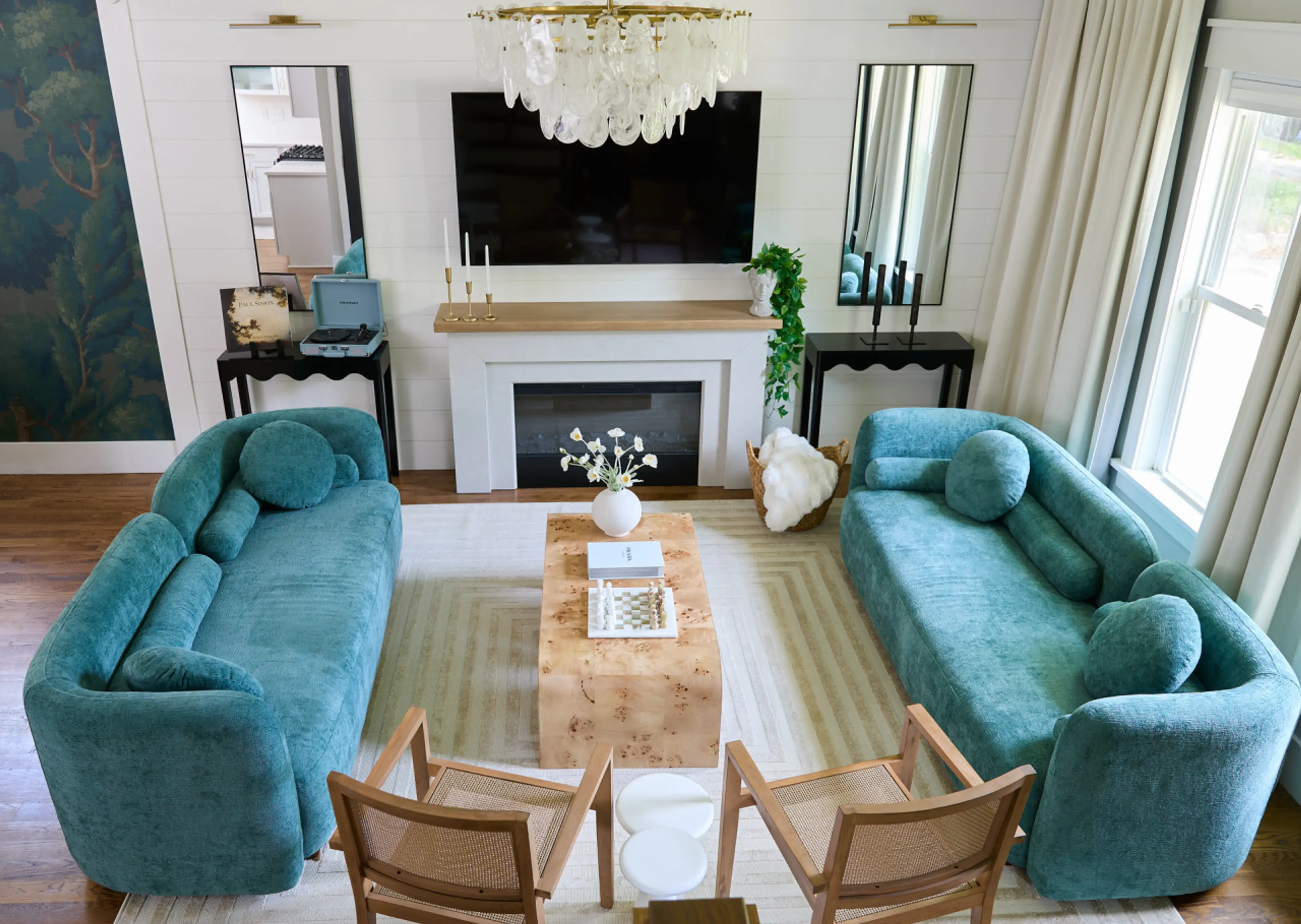 Designer living room with plush velvet sofas, a cozy fireplace, and curated textures — the perfect space to relax, connect, and unwind in your luxury Raleigh Airbnb.