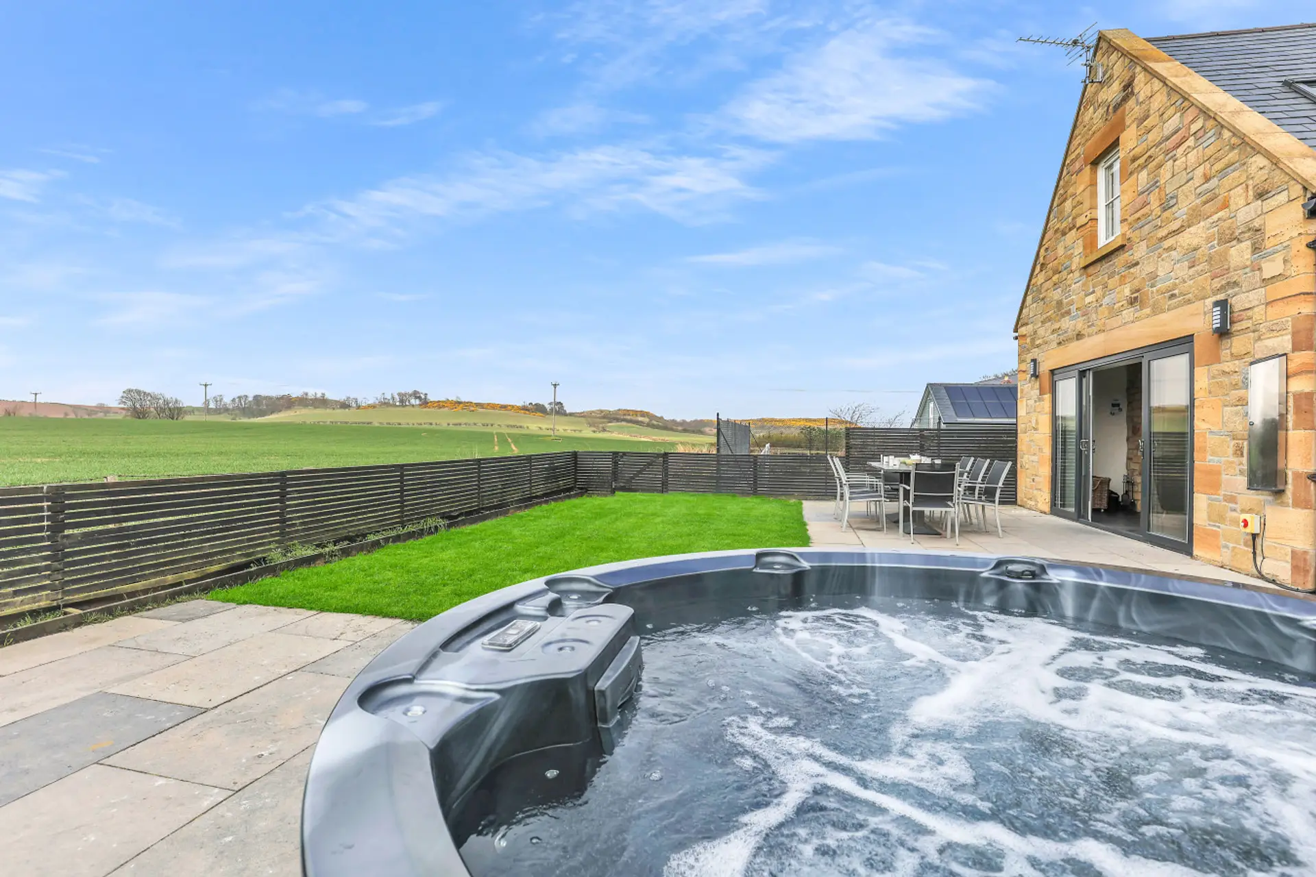 Private hot tub beside the enclosed garden and countryside views