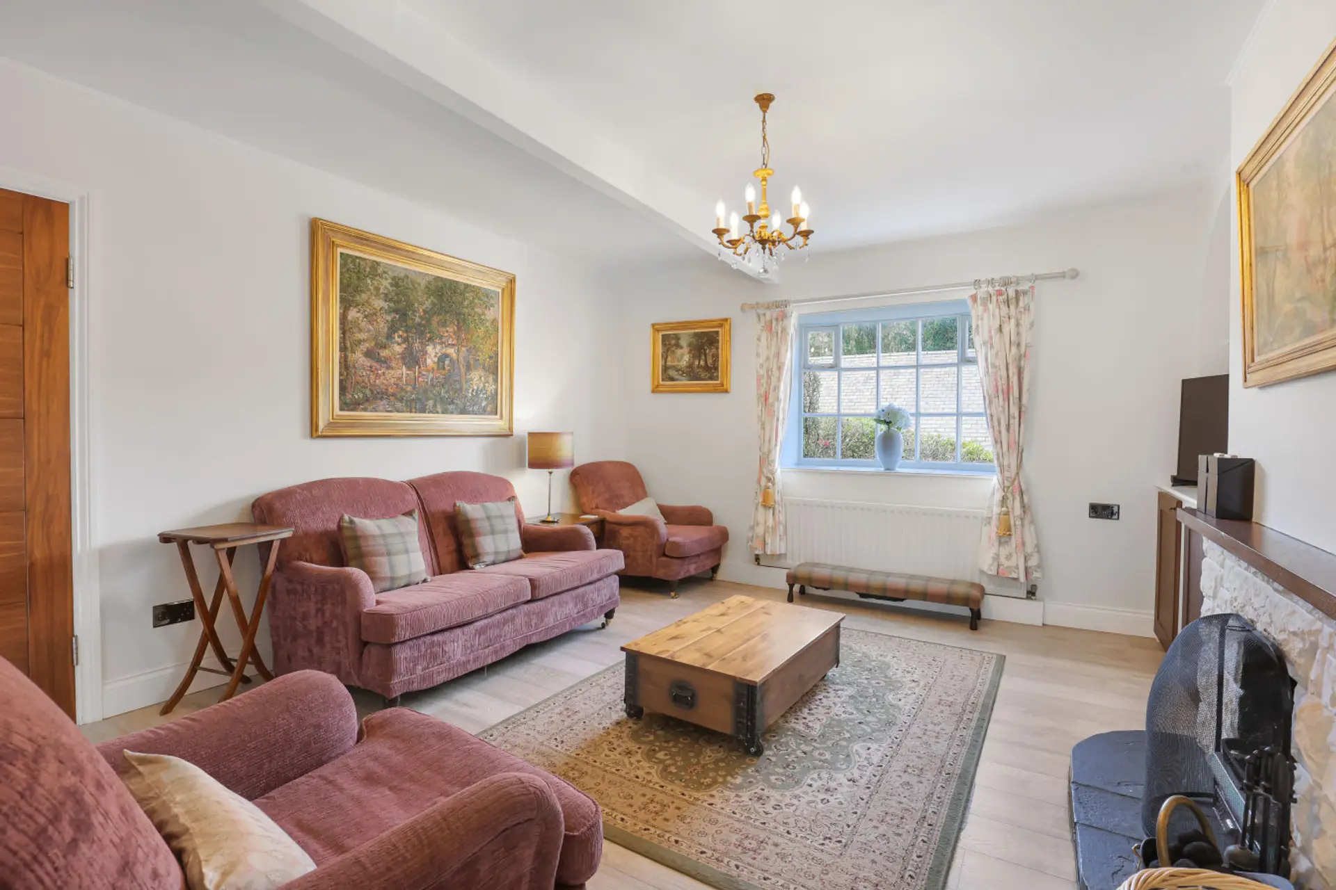Lounge with open fire, upholstered sofas and framed artwork
