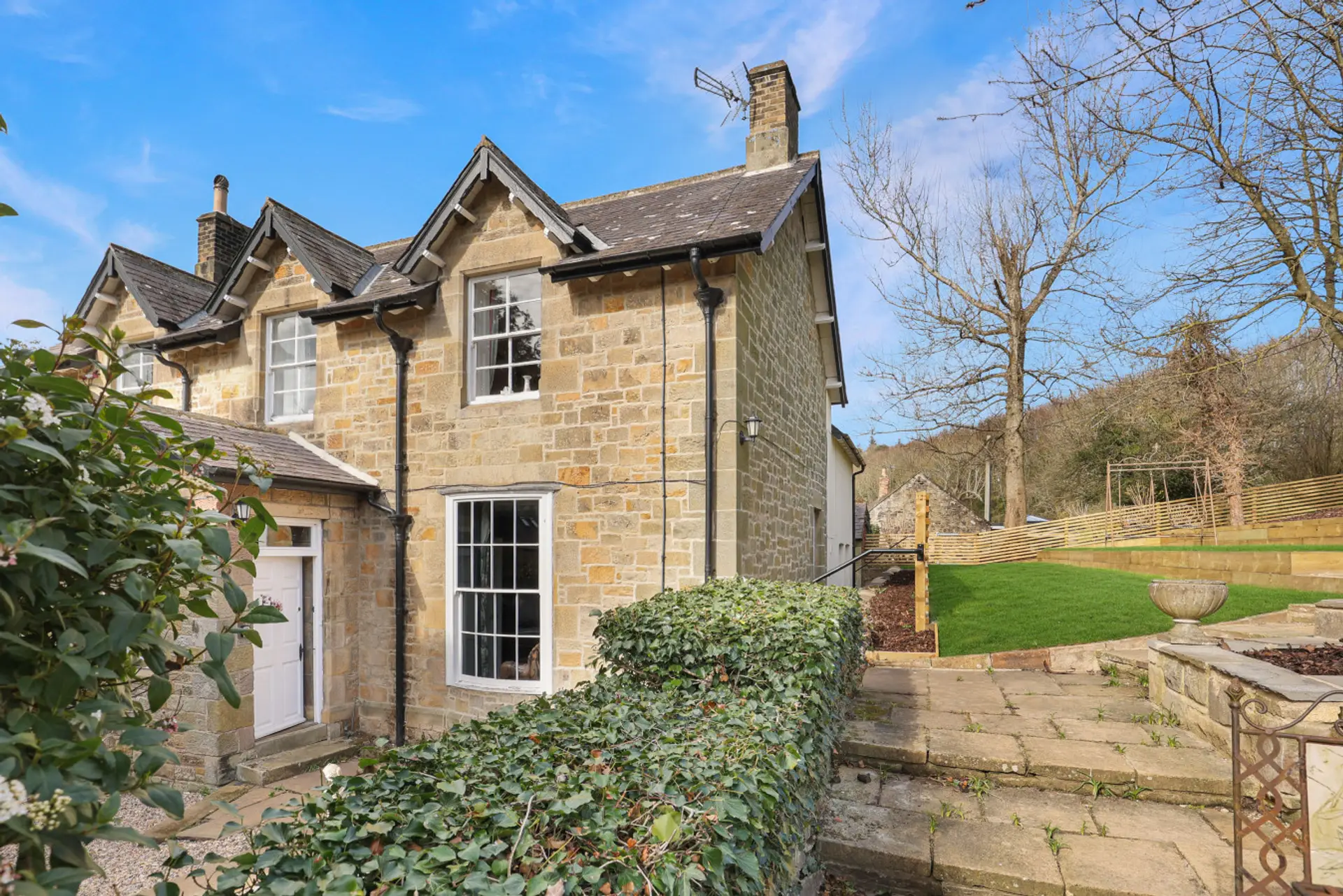 Stone-built Spindlestone House with lawned garden and mature trees