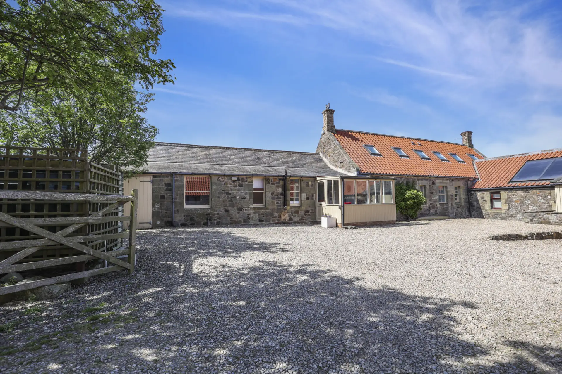 Stone cottage with gravel courtyard and conservatory